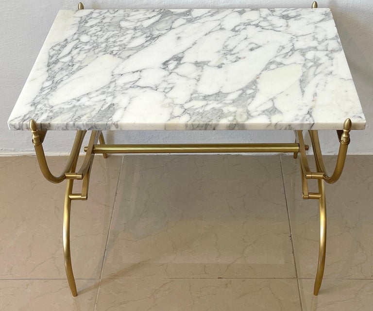 Italian Mid-Century Modern carrara marble & brass coffee/side table, with beautiful variegated Carrara marble top resting on a satin brass stylized Curule base. The marble top is removable, from the base for shipping.