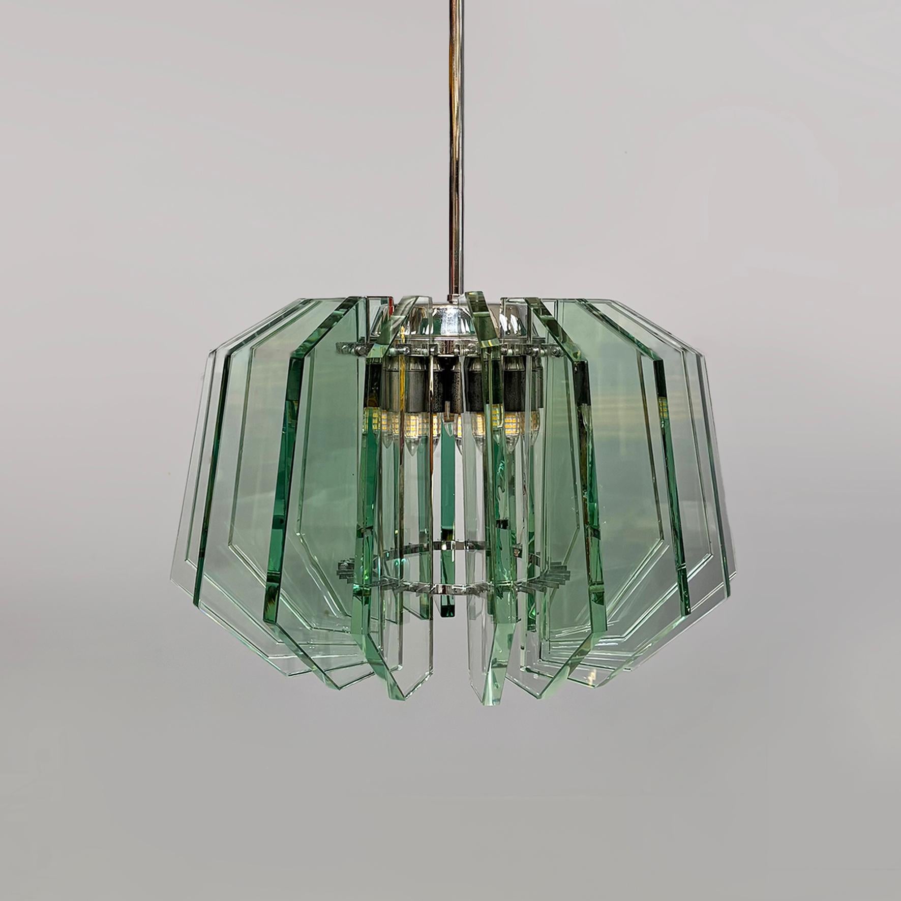 Araña moderna italiana de mediados de siglo de Max Ingrand para Fontana Arte, años 60
Araña de cristal con base redonda. La pantalla está compuesta por dieciocho láminas de vidrio transparente, perfiladas y rectificadas con líneas geométricas que se