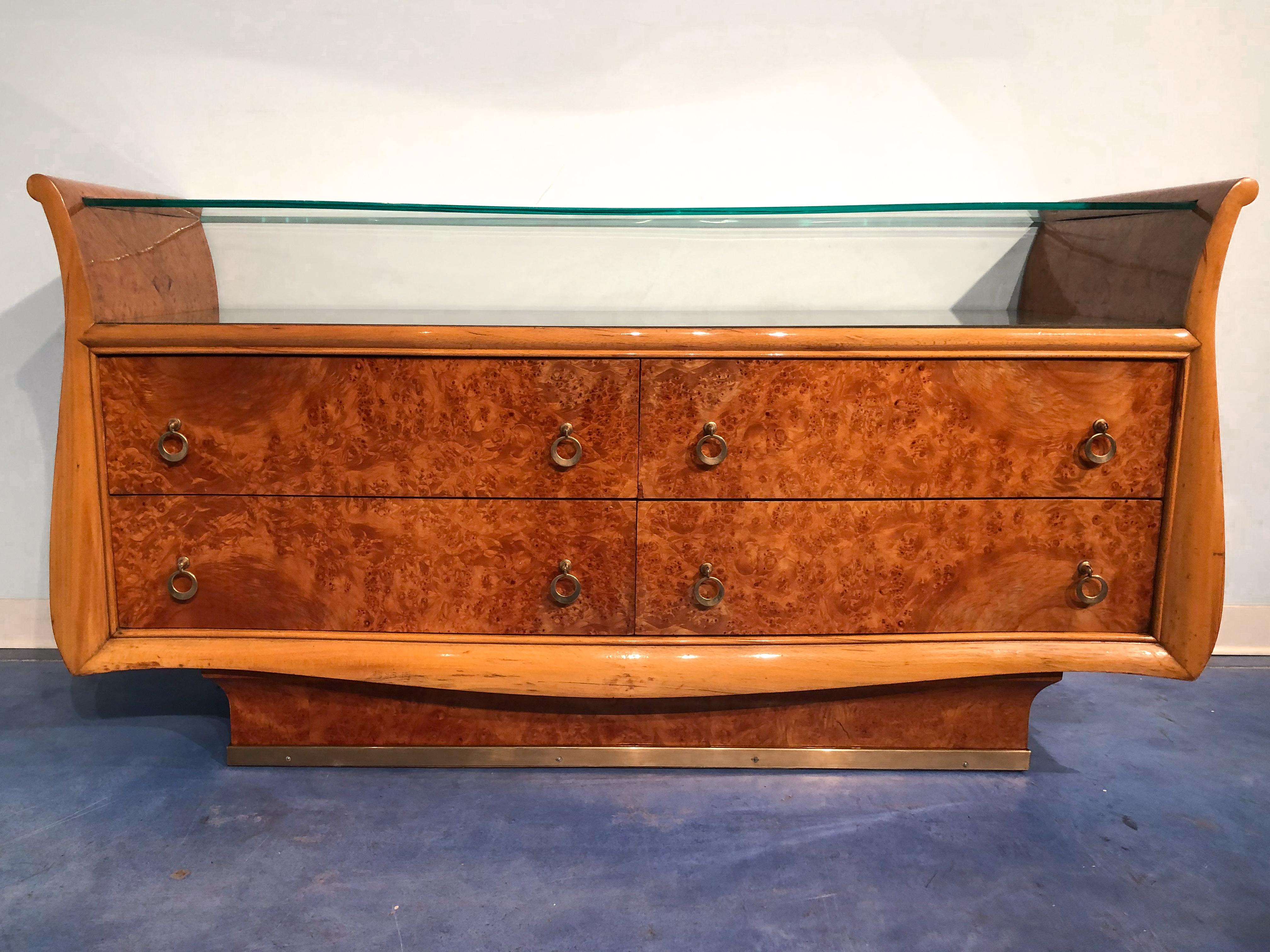 Stilvolles italienisches Mid-Century Modern Sideboard oder Kommode aus Birkenwurzel mit Doppelplatte aus geformtem Glas.
Sehr raffiniertes Seitendesign, unterer Sockel mit vertikaler geschwungener Linie und Sockel aus Messing. Diese prächtige