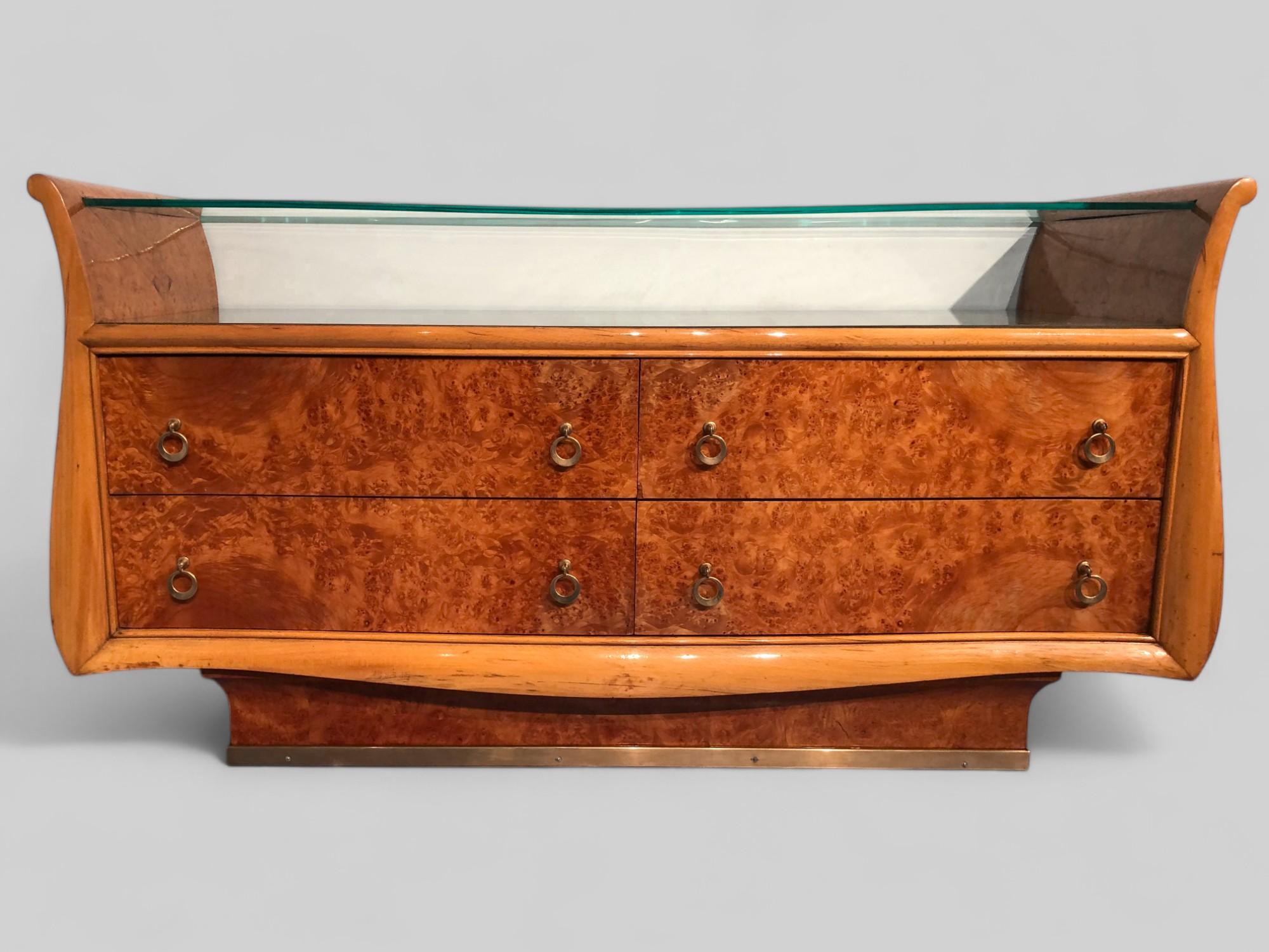 Stylish Italian Mid-Century Modern sideboard or chest of drawers in birch briar root with double top in shaped glass.
Very refined sides design, lower base with a vertical curved line and brass base finish. This magnificent chest of drawers or