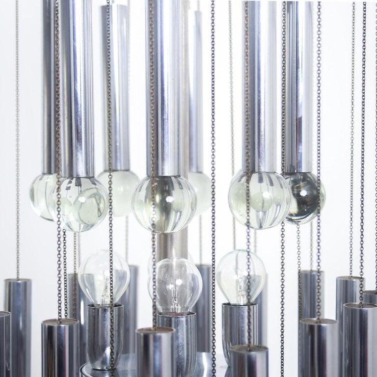 Gaetano Sciolari chandelier featuring three tiers of chrome cylinders and glass balls. Produced circa 1970, Italy.
 