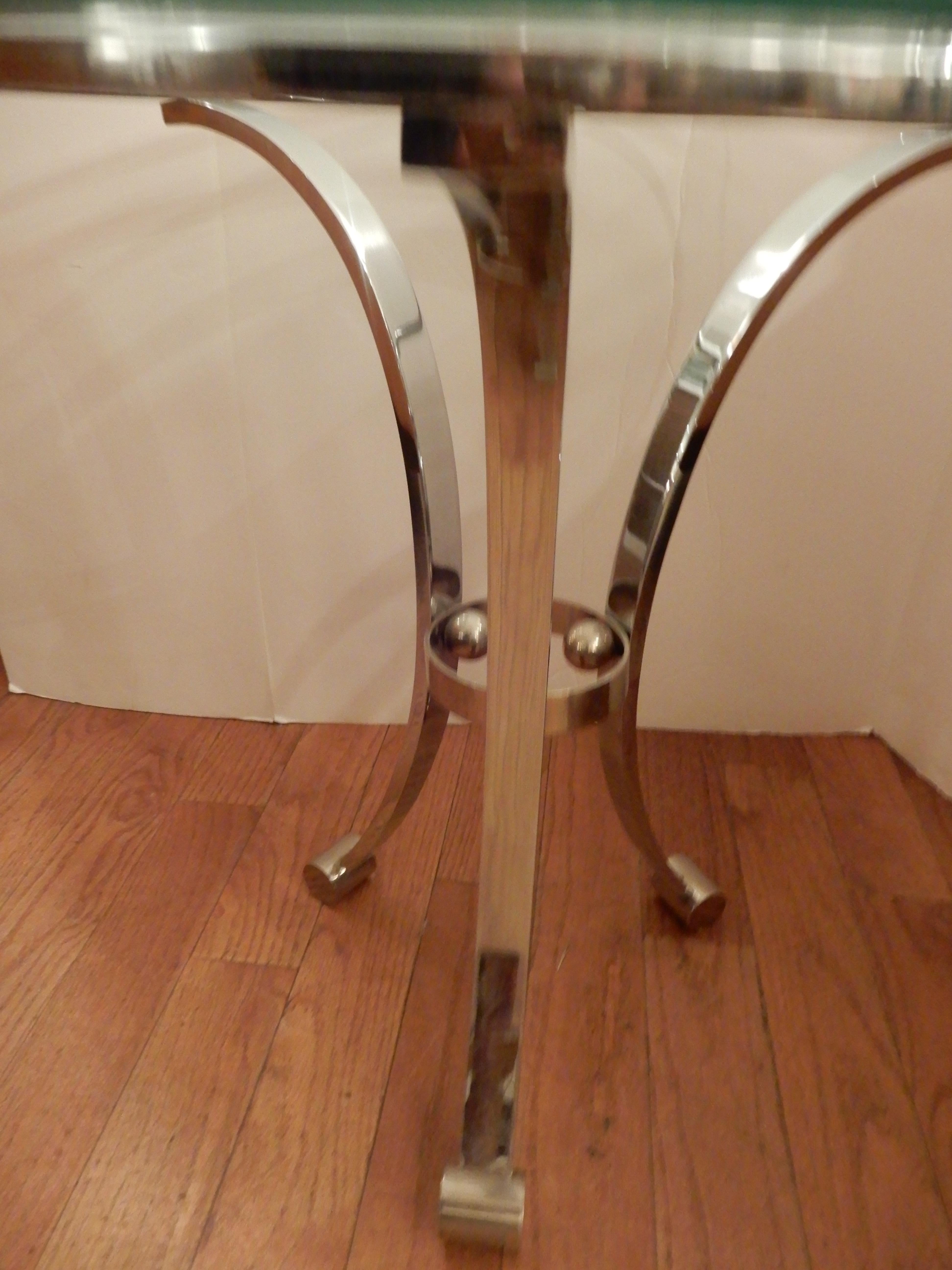 A curvaceous chrome and glass Mid-Century Modern side table, end table, fabulous details throughout, turned feet, three sphere's in center, an interesting and useful piece. The glass is 1/2 inch thick, heavy chrome base.