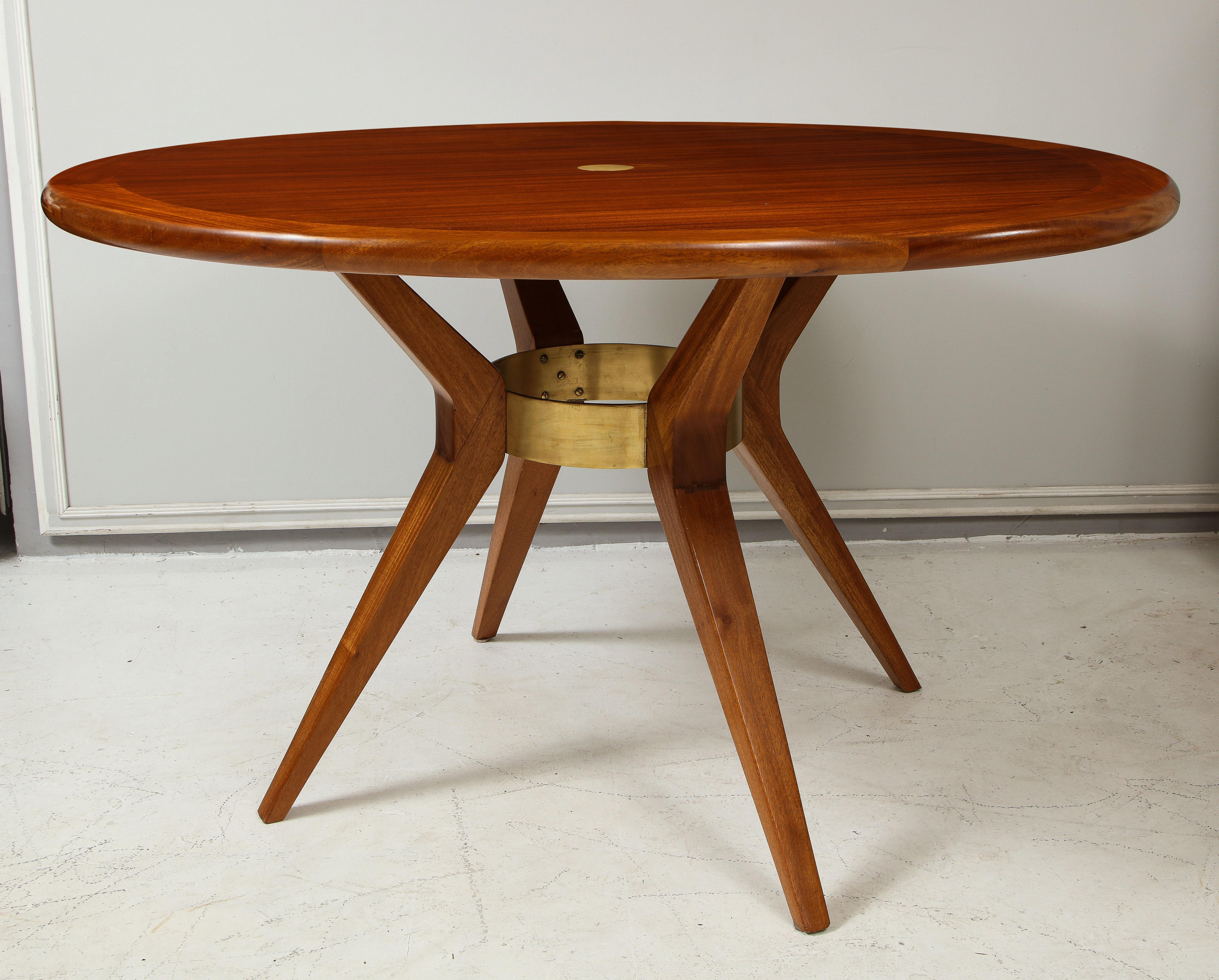 Italian Mid-Century Modern mahogany circular dining table/ center table with central bronze ring on tripod base.