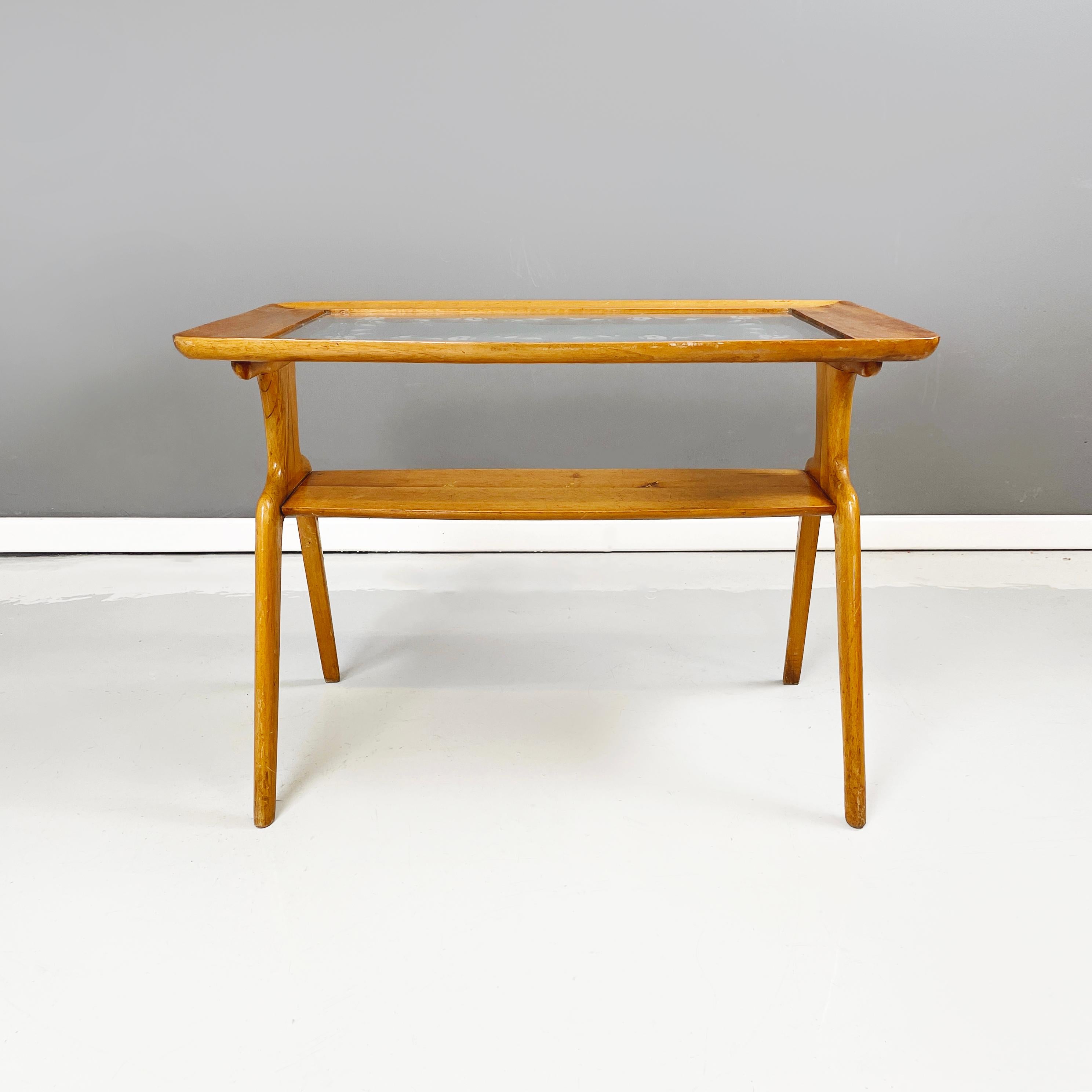Italian mid-century modern Coffee table in wood and decorated glass, 1950s
Coffee table with glass top decorated with floral motifs and wooden profile. The structure is made of light wood. Under the floor there is a second smaller shelf, which can