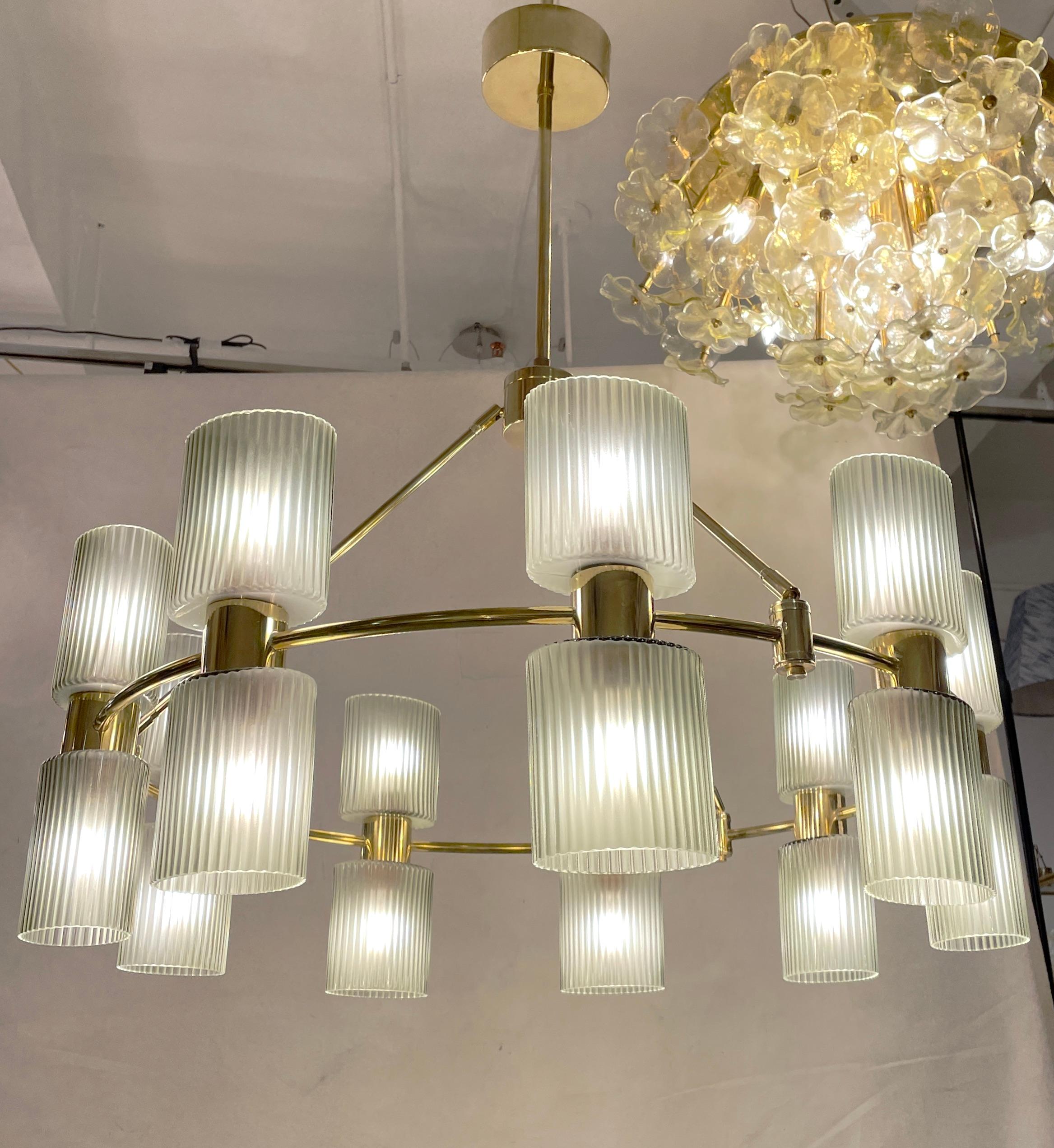 What's old is new again! A sophisticated modern interpretation of the design of a barn farmhouse candle wheel chandelier, this contemporary organic 18-light creation, entirely handcrafted, is customizable in sizes, finishes and glass colors. The