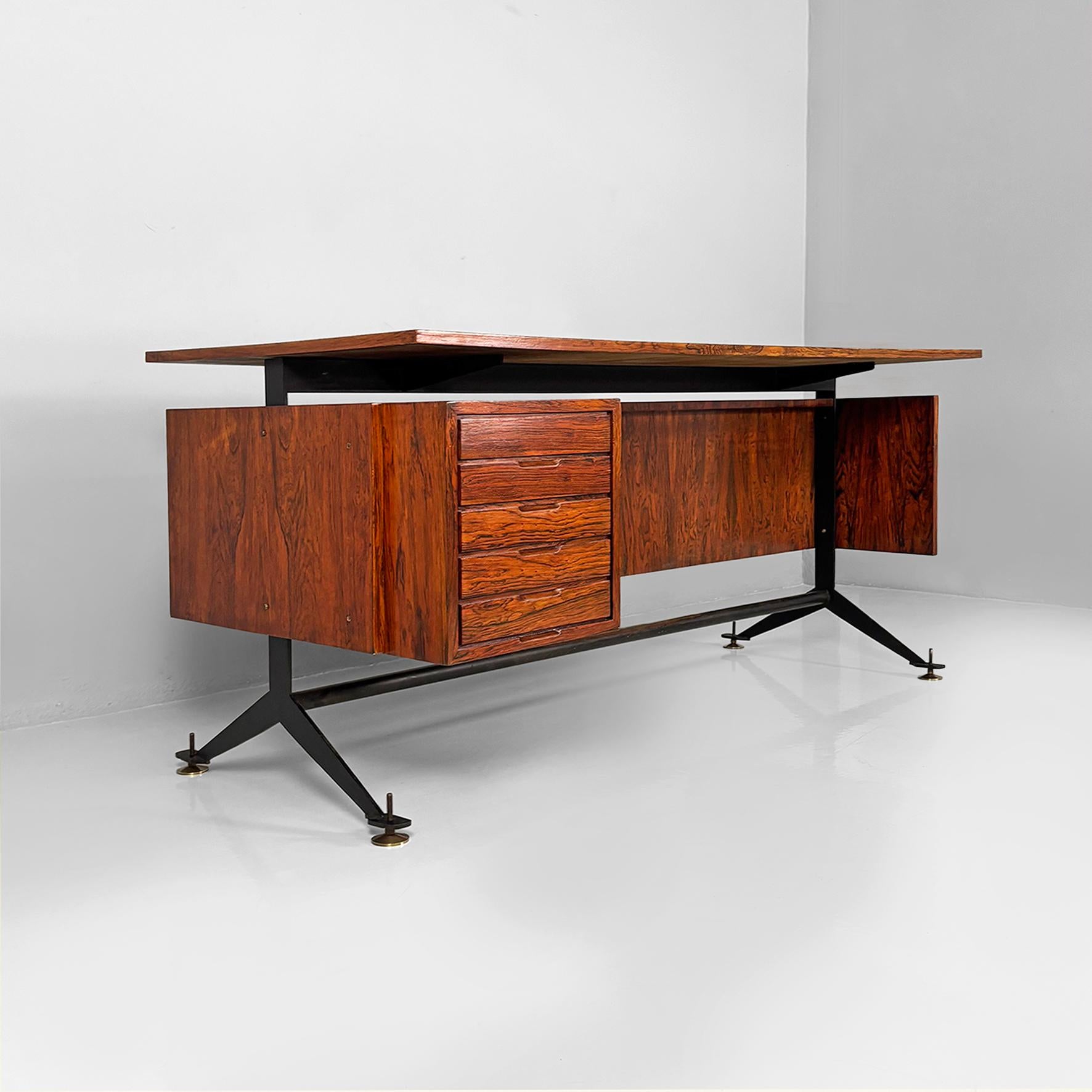 Escritorio italiano moderno de mediados de siglo en madera, metal negro, laminado beige y latón, años 60
Escritorio con tablero rectangular de madera revestido de laminado beige. En el lateral hay una cómoda con cinco cajones de madera. La