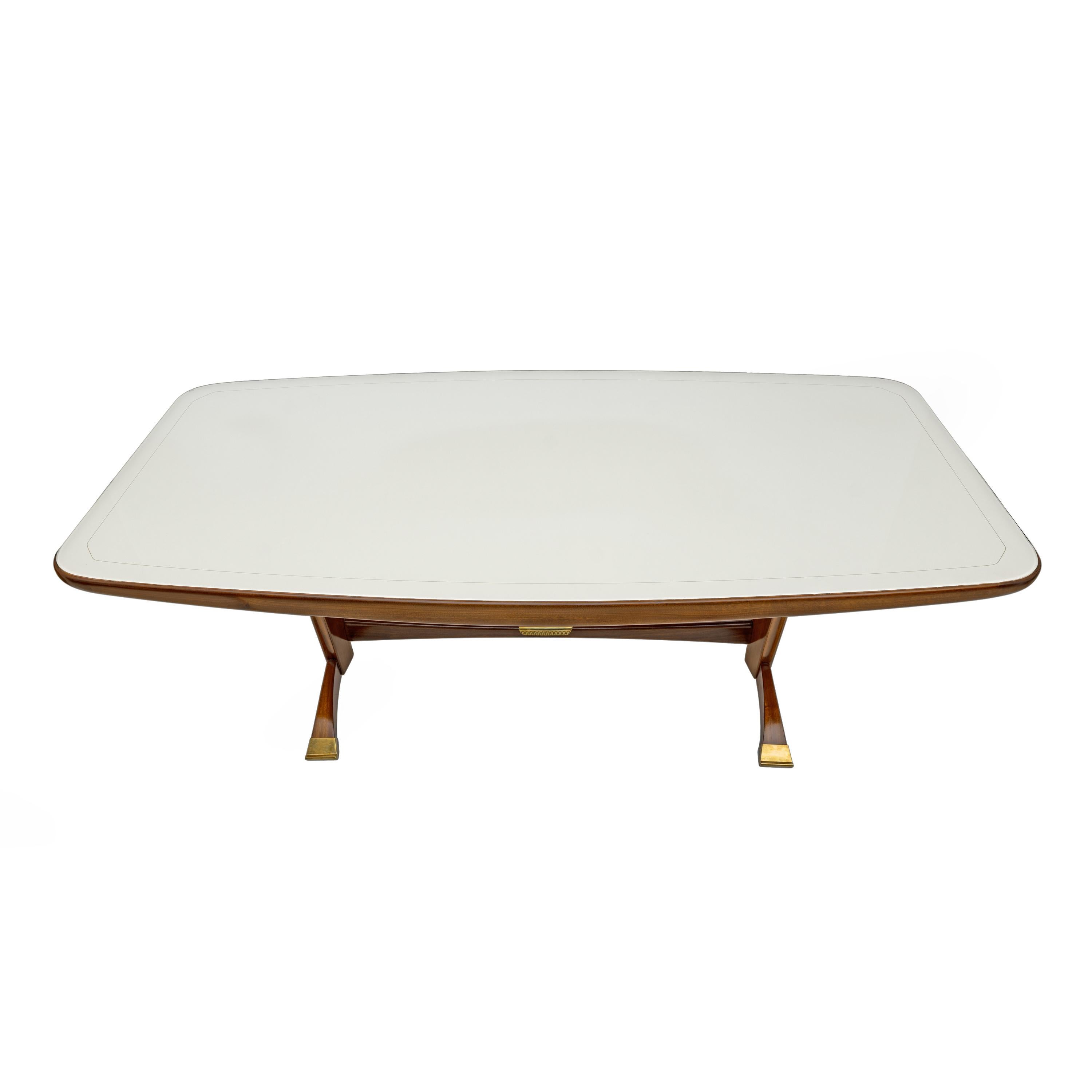 Attributed to Paolo Buffa, a 1950s table in mahogany-stained walnut, walnut burl sides, brass, and a glass top. Completely restored and polished with shellac. As pictured, it has a small flaw on the edge, missing enamel.
