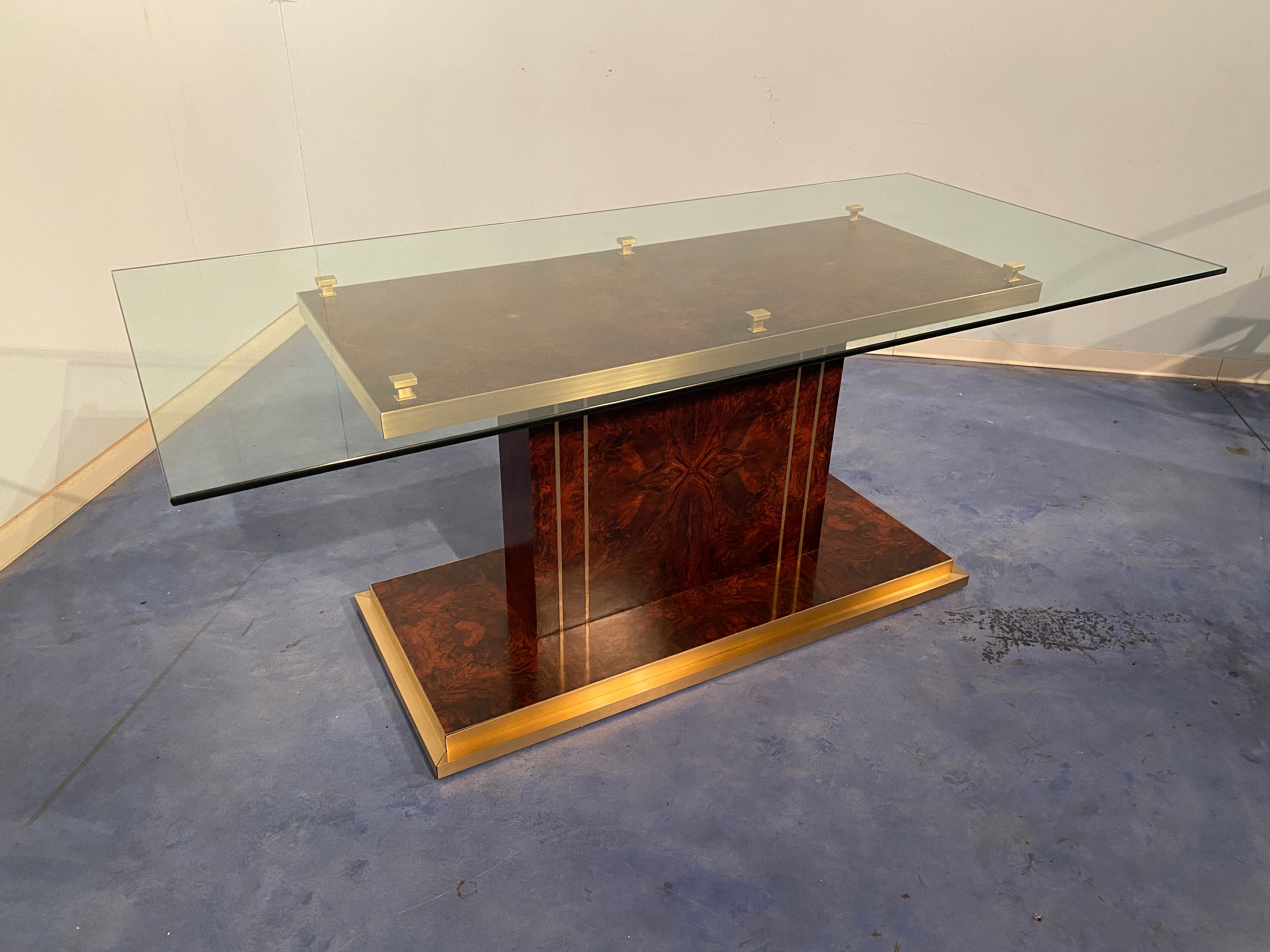 Élégante table à manger italienne de style moderne du milieu du siècle dernier, 1970. La forme du plateau est rectangulaire avec un verre épais, la base est dans une splendide racine de noyer avec des détails raffinés en laiton. Cette magnifique