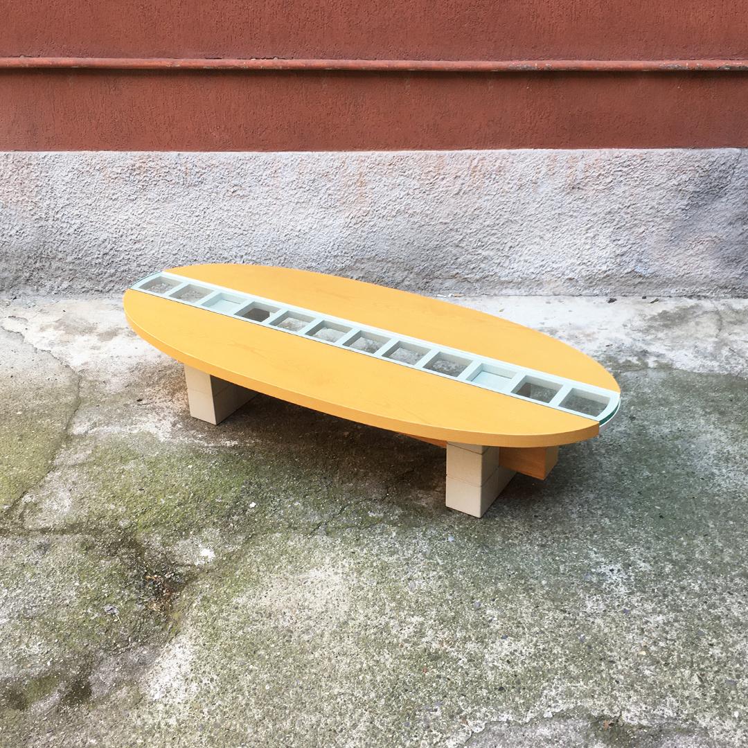 Italian Mid-Century Modern elliptical solid wood coffee table, 1980s
Elliptical solid wood coffee table, with parts painted in white, and central sliding glass top, which opens to create compartments for bottles and glasses.
Coming from the house