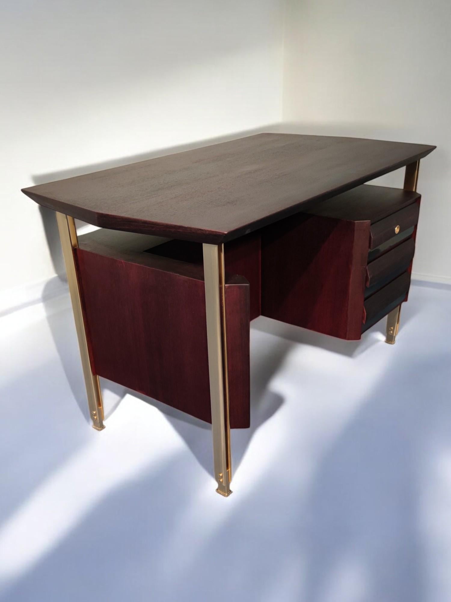 Élégant bureau de direction italien Mid-Century Modern de couleur bordeaux, conçu par Vittorio Dassi dans les années 1960. De forme hexagonale, le double support de barre en laiton avec de hauts pieds réglables présente un design vraiment unique.