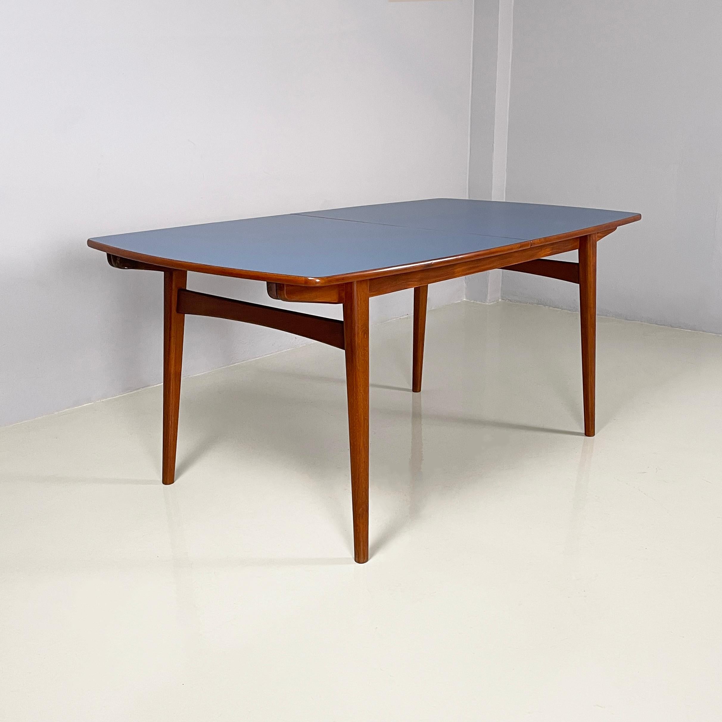 Italian mid-century modern extendable dining table in wood and blue formica, 1960s
Extendable dining table in wood and blue formica. The blue formica top with wooden profiles has a square shape with rounded corners, to which two wooden extensions