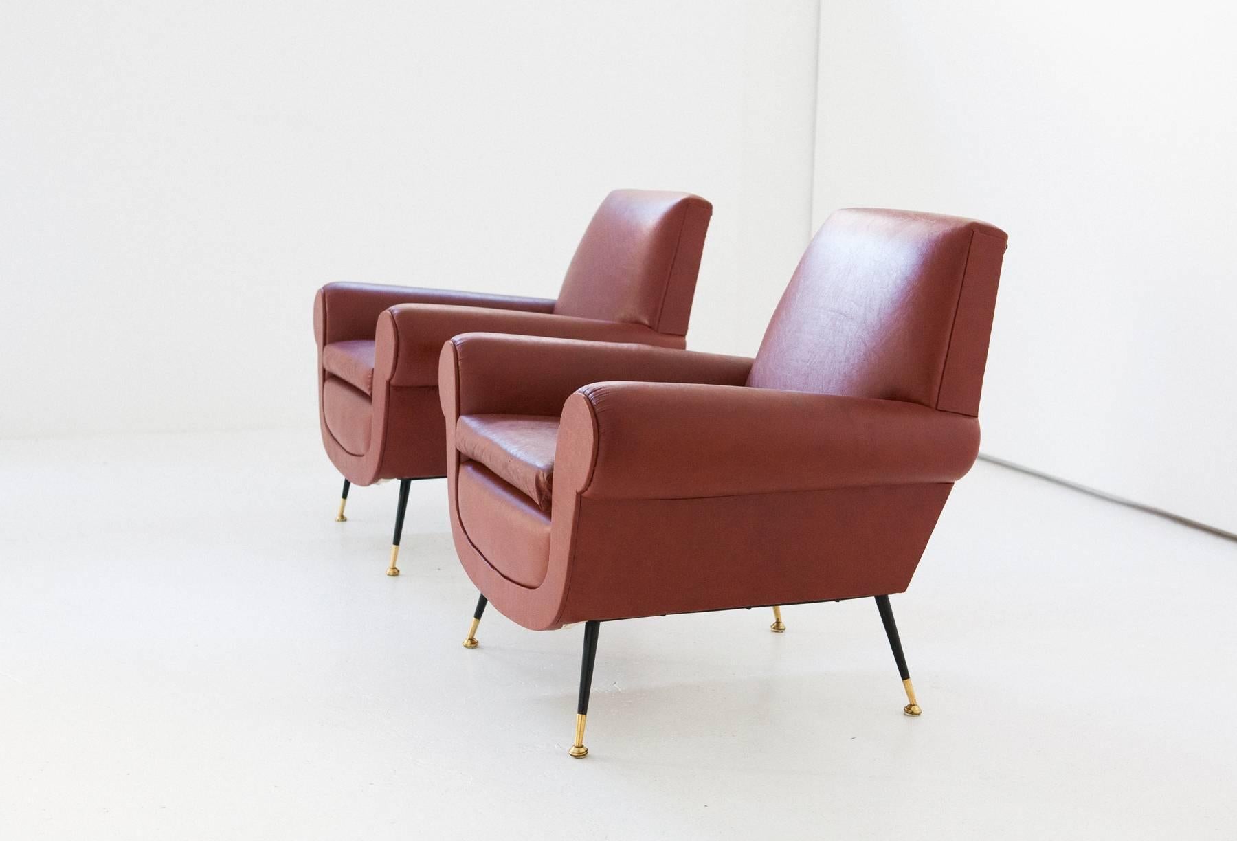 Set of two armchairs in faux brown or orange leather with iron legs and brass feets
Italian design by Gigi Radice for Minotti
1950s.

The upholstery and upholstery are original and are in good condition
You can request the replacement of the