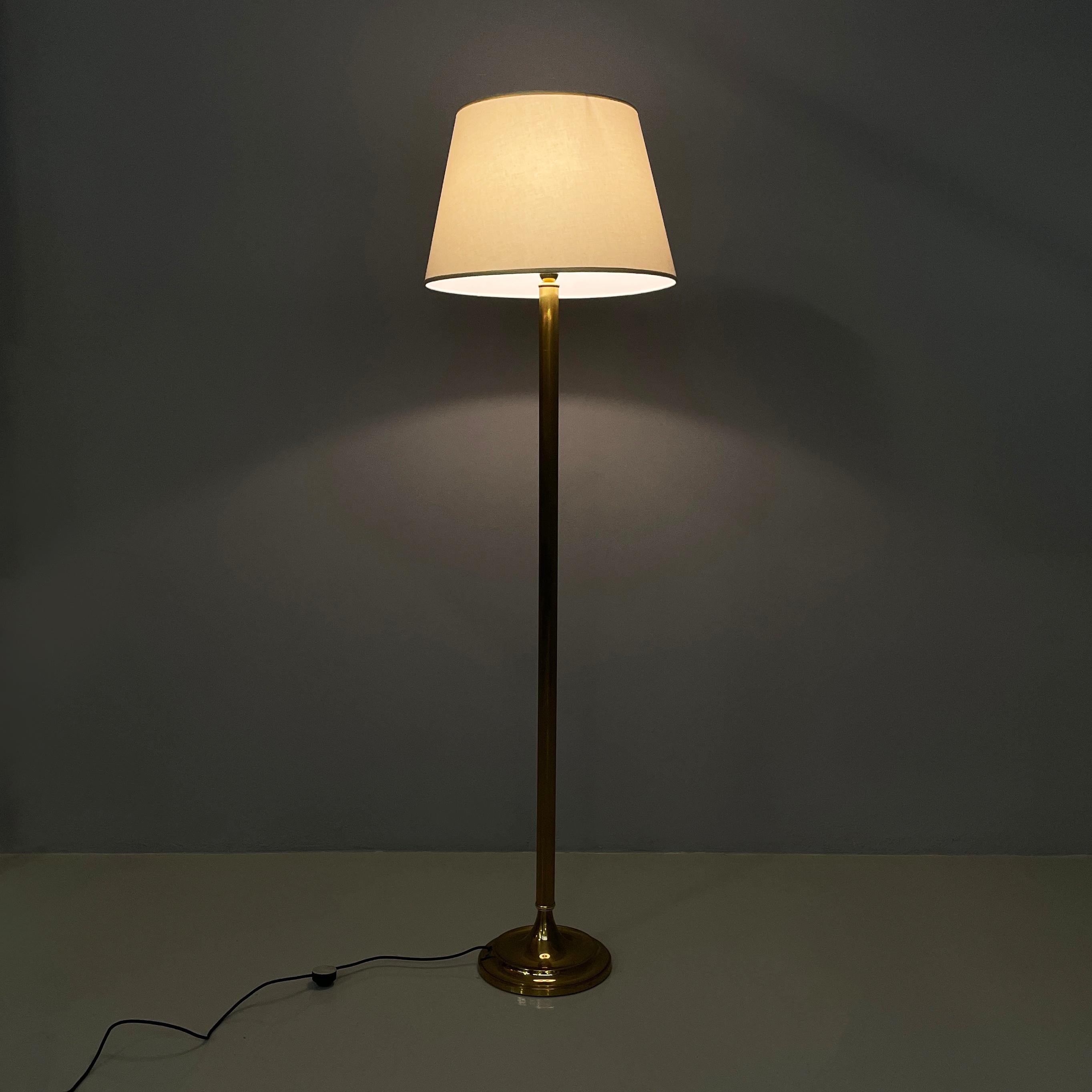Lampada da terra italiana di metà secolo in tessuto e ottone di LAM Bologna, anni '60
Lampada da terra con paralume in tessuto bianco e rifiniture bianche sui bordi. La struttura è realizzata in ottone con scanalature decorative. Round brass