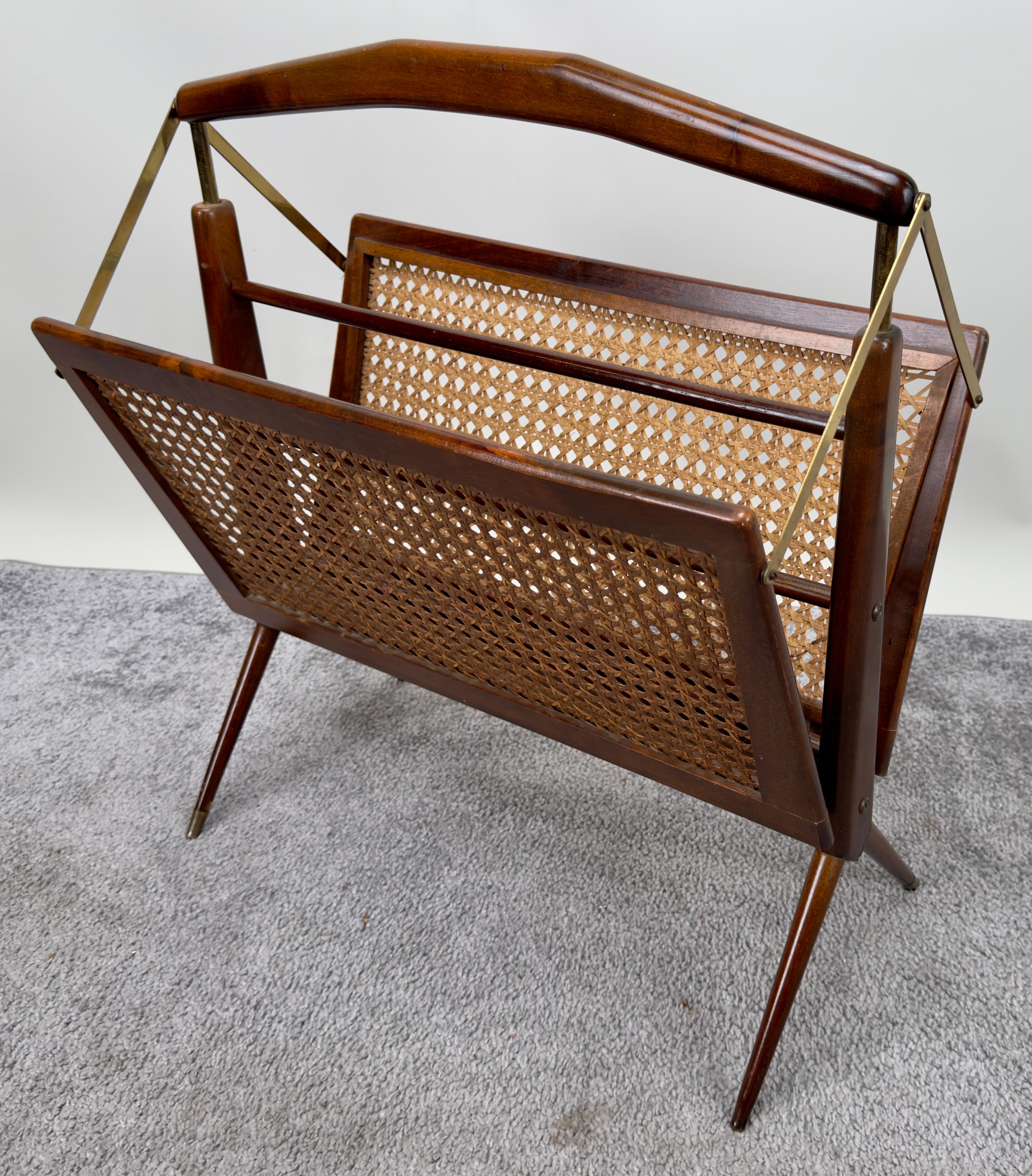  A folding magazine rack crafted by tCesare Lacca ( Italian - Born 1929- 1978 ). This exquisite piece showcases elegant cane sides gracefully accentuated by gleaming brass details. With its seamless blend of style and practicality, this magazine