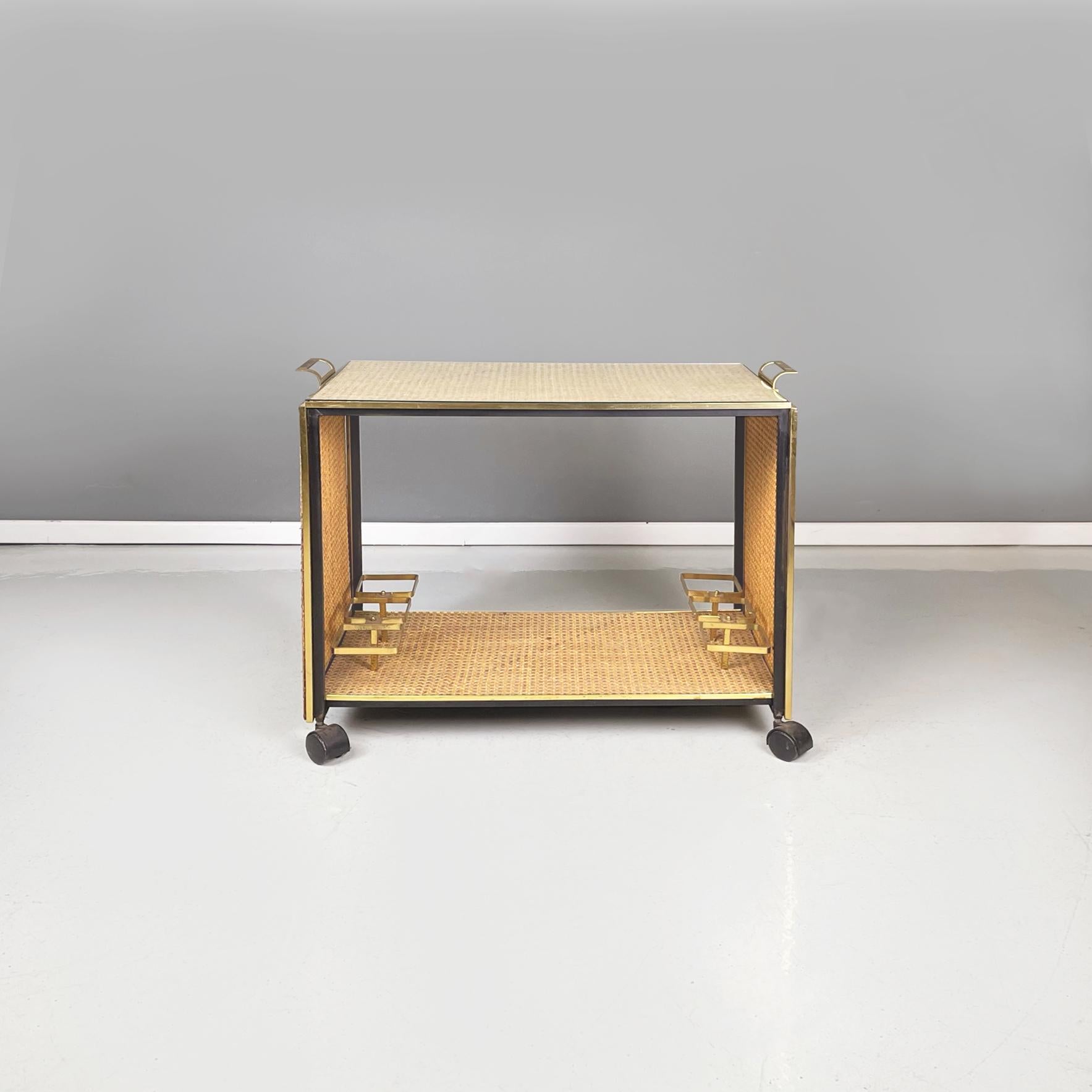 Italian Mid-Century Modern Food cart in straw, black metal and brass, glass, 1950s
Bar cart with double shelf in straw, metal, brass and glass. The black painted metal structure is covered in the center with woven straw and on the profiles with