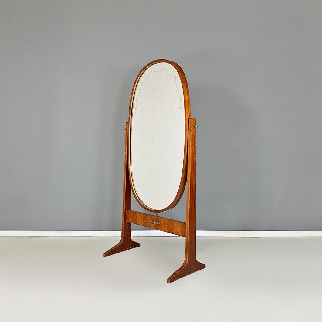 Miroir de sol ovale en bois, sur pied, pleine longueur, italien, milieu du siècle dernier, années 1950
Miroir de sol sur pied, de forme ovale, à structure entièrement en bois avec des décorations sur le cadre et sur la vitre. Détails en laiton sur