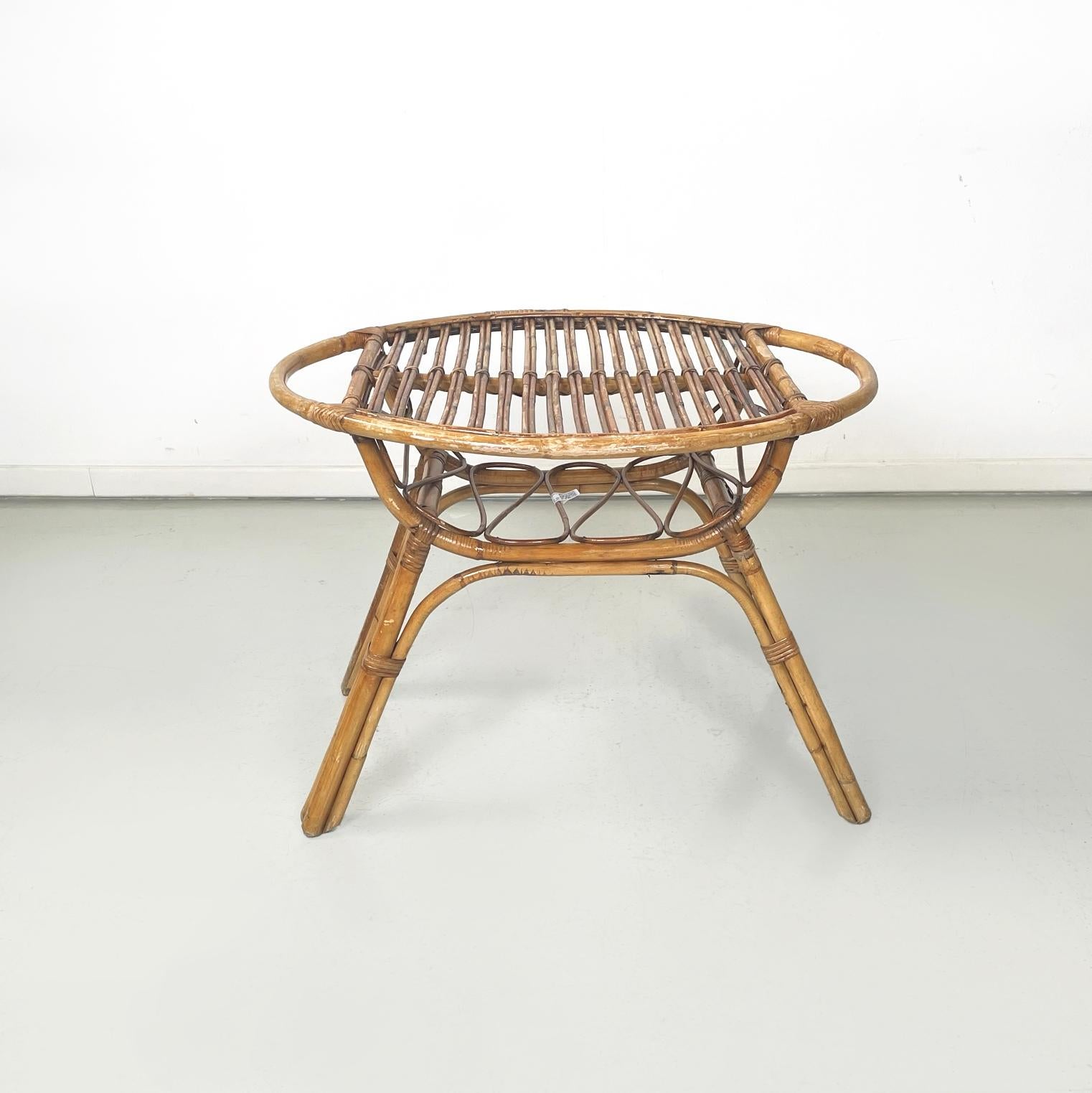 Italian mid-century modern Garden oval coffee table in rattan, 1960s
Coffee table entirely in rattan with elegant weaves. The coffee table has an oval top and a lower storage shelf with a repeated curvilinear pattern. The table is suitable for