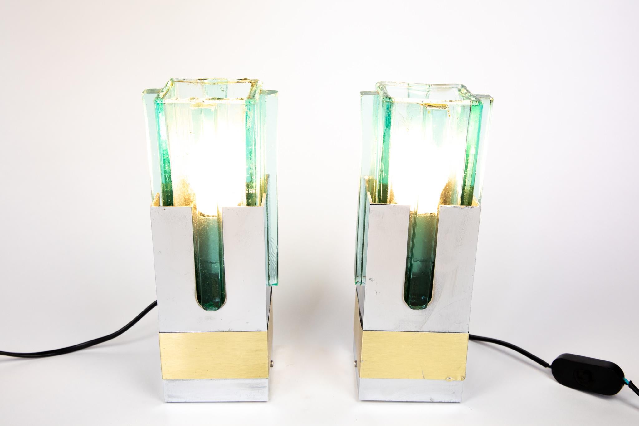 Pair of  Table Lamps in Turquoise Glass, Brass and Chrome, Italy, 1970s.

Very rare set of two mid-century Italian table lamps made of three different materials. The top of the lamps are made of thick glass in a square shape with rounded corners and