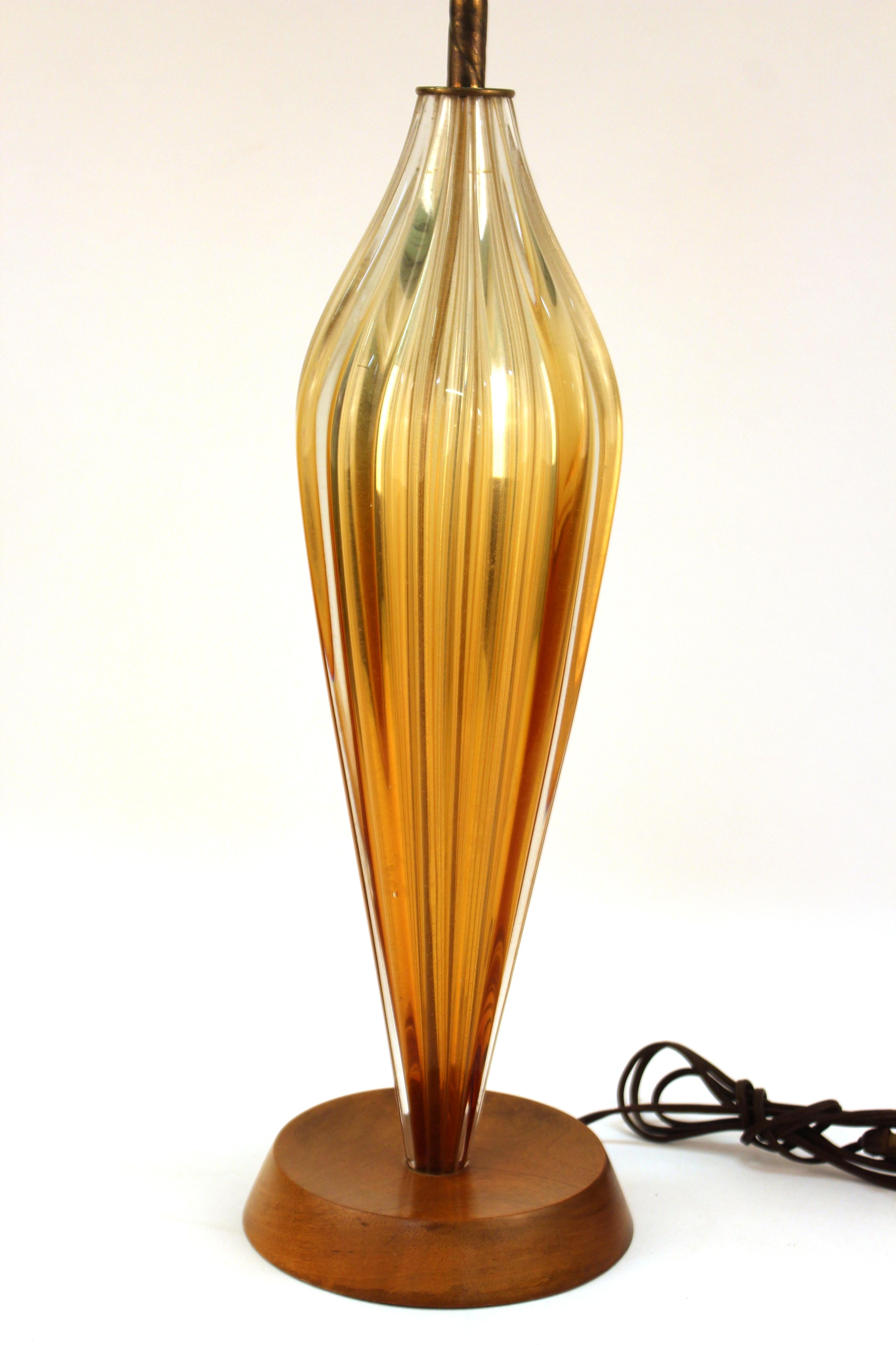 Italian Mid-Century Modern glass table lamp in elongated shape atop a circular wooden base. The piece is in great vintage condition with some minor age-related wear to the bottom of the base.
