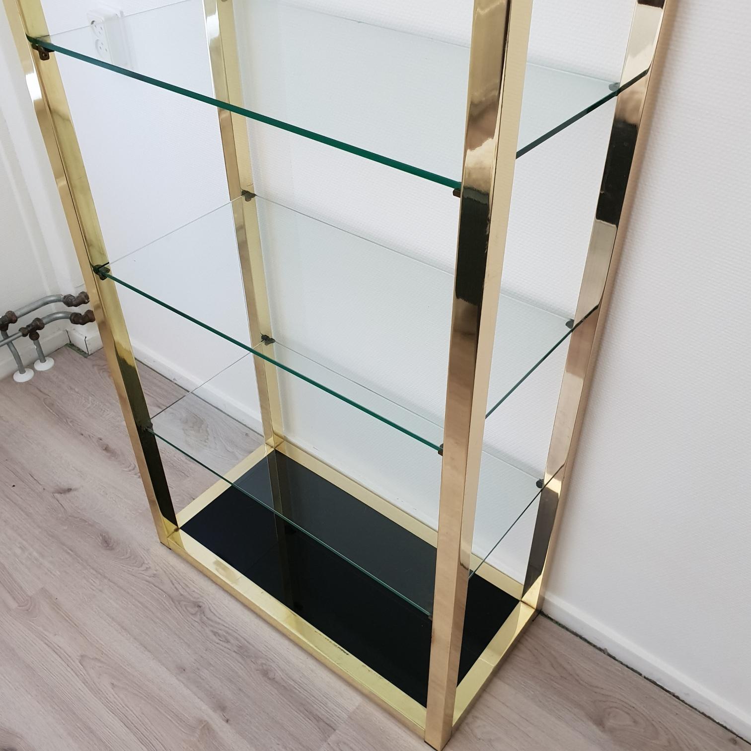 Italian Mid-century Modern gold plated shelving unit étagère with clear and black glass, 1970s.
Heavy and very good quality.
 