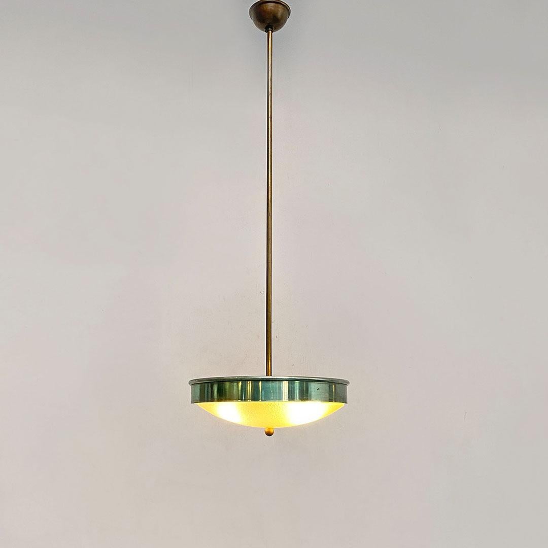 Italian Mid-Century Modern green metal, glass and brass chandelier, 1950s
Suspension lamp with emerald green metal lampshade supporting the worked glass diffuser, with central ball and brass stem.
About 1950s.
Good general condition, some signs