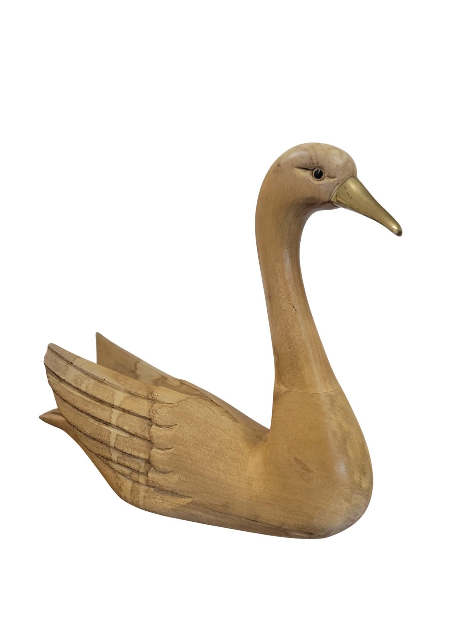 Cet élégant cygne en bois sculpté à la main est un exemple raffiné de l'art décoratif italien du Modern-Decor, datant des années 1960-1970. Sculptée dans des lignes douces et organiques qui capturent à la fois la grâce et la simplicité, la figure