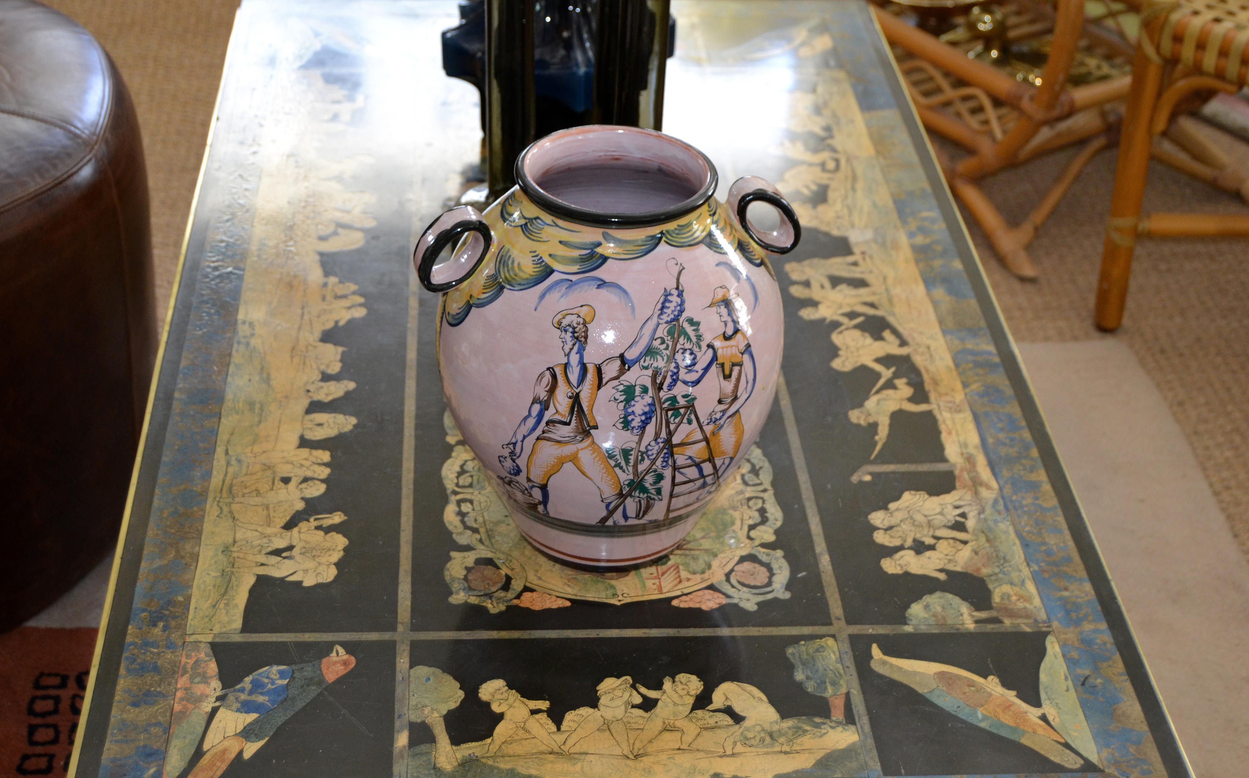 Vase ou récipient en terre cuite vernissée et peinte à la main, vers 1979, en provenance d'Italie.
Le vase représente deux motifs différents, d'un côté deux hommes portant une grappe de raisin et de l'autre des hommes cueillant du raisin.
Le vase