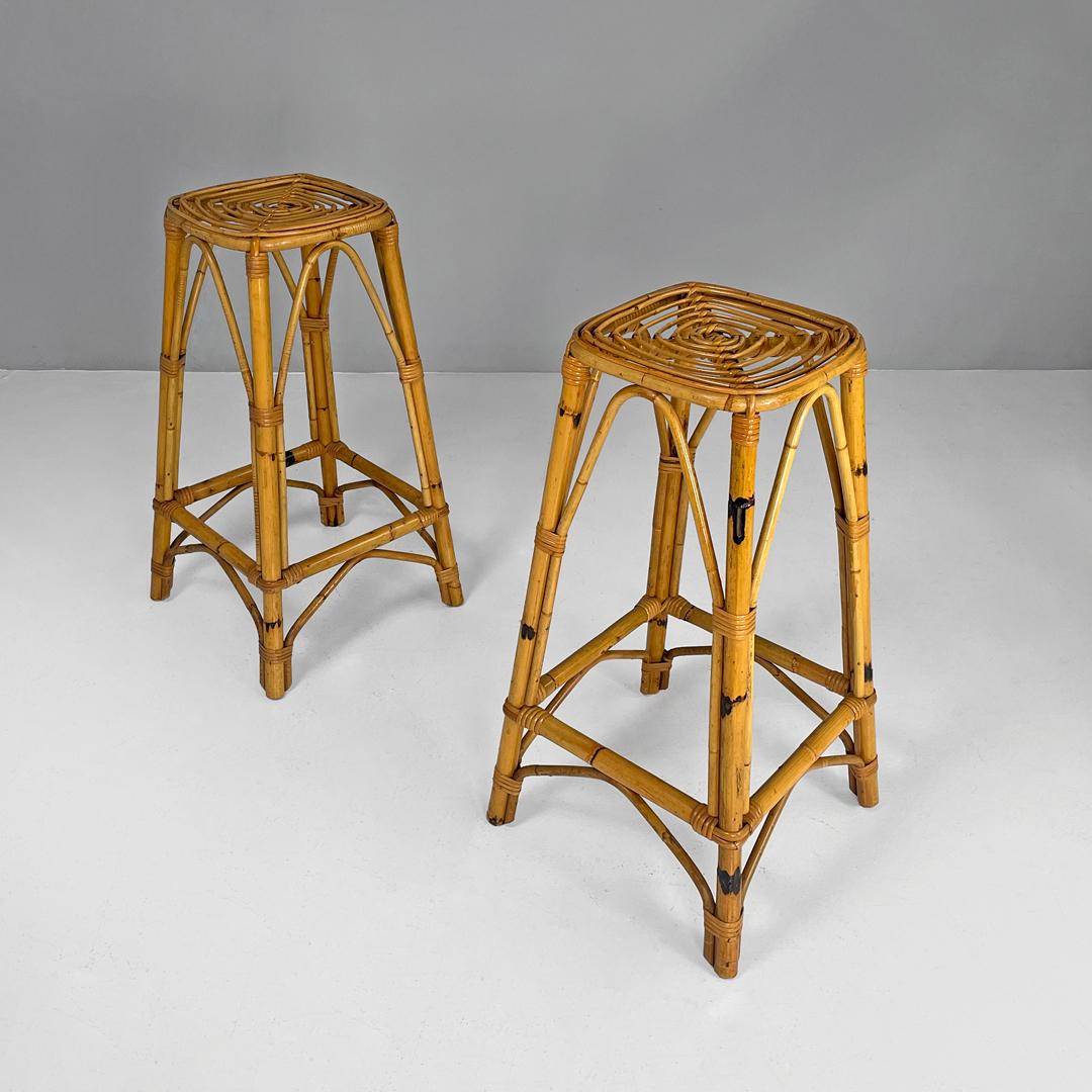 Italian mid-century modern high rattan bar stools with square base, 1960s
Pair of high rattan bar stools with square base. The seat is square with rounded corners and has a spiral motif, the four legs widen slightly when placed on the ground. In the