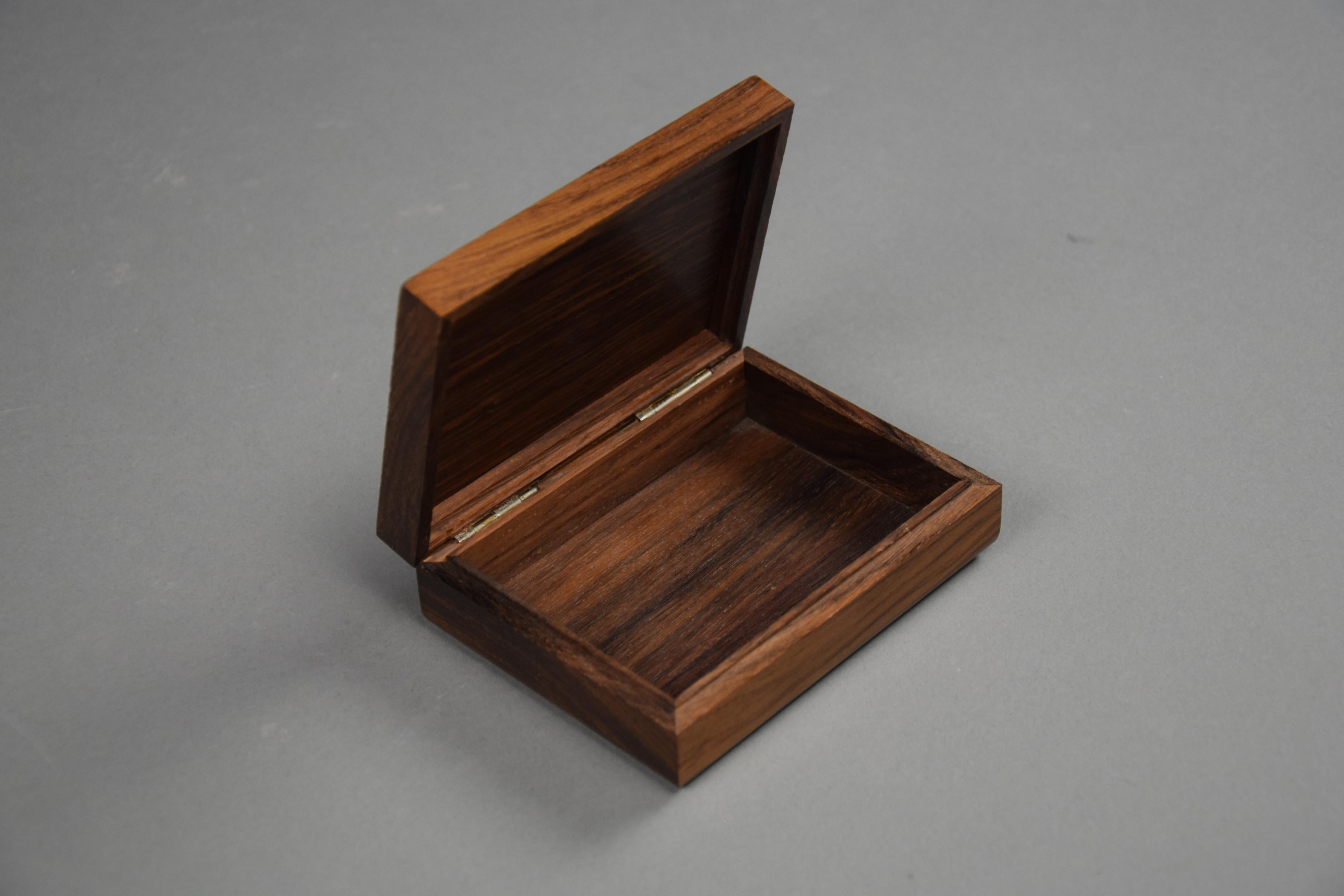 Introducing the epitome of sophistication: the Italian Mid Century Modern Jatoba Wood and Floral Decorated Silver Plated Cigarette Box by Ottaviani. Crafted with utmost precision and adorned with timeless elegance, this masterpiece adds a touch of