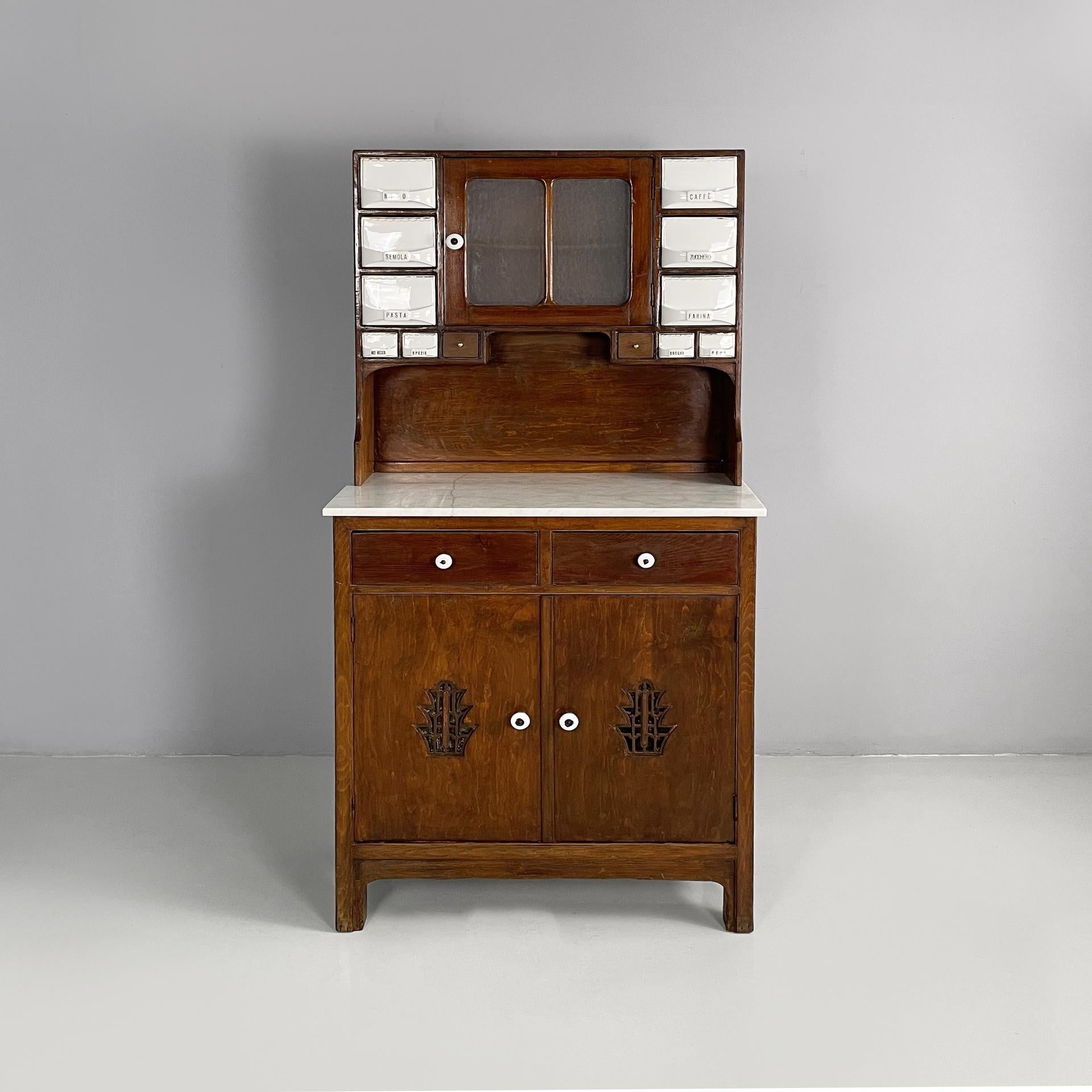 Credenza da cucina italiana di metà secolo in legno, marmo e ceramica, anni '30
Credenza da cucina rettangolare a due moduli con struttura in legno. La parte superiore presenta uno scomparto centrale con un'anta a battente in vetro e legno, con un