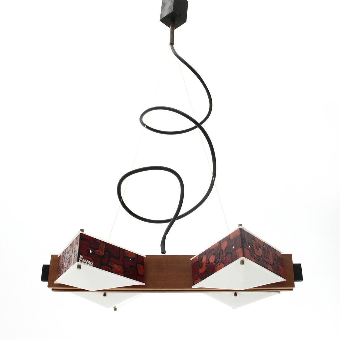 Chandelier made by Esperia in the 1960s on a project by Angelo Brotto.
Central body in black painted metal, covered with two teak bands.
Diffusers in enameled metal and white perspex.
Good general conditions, some signs due to normal use over
