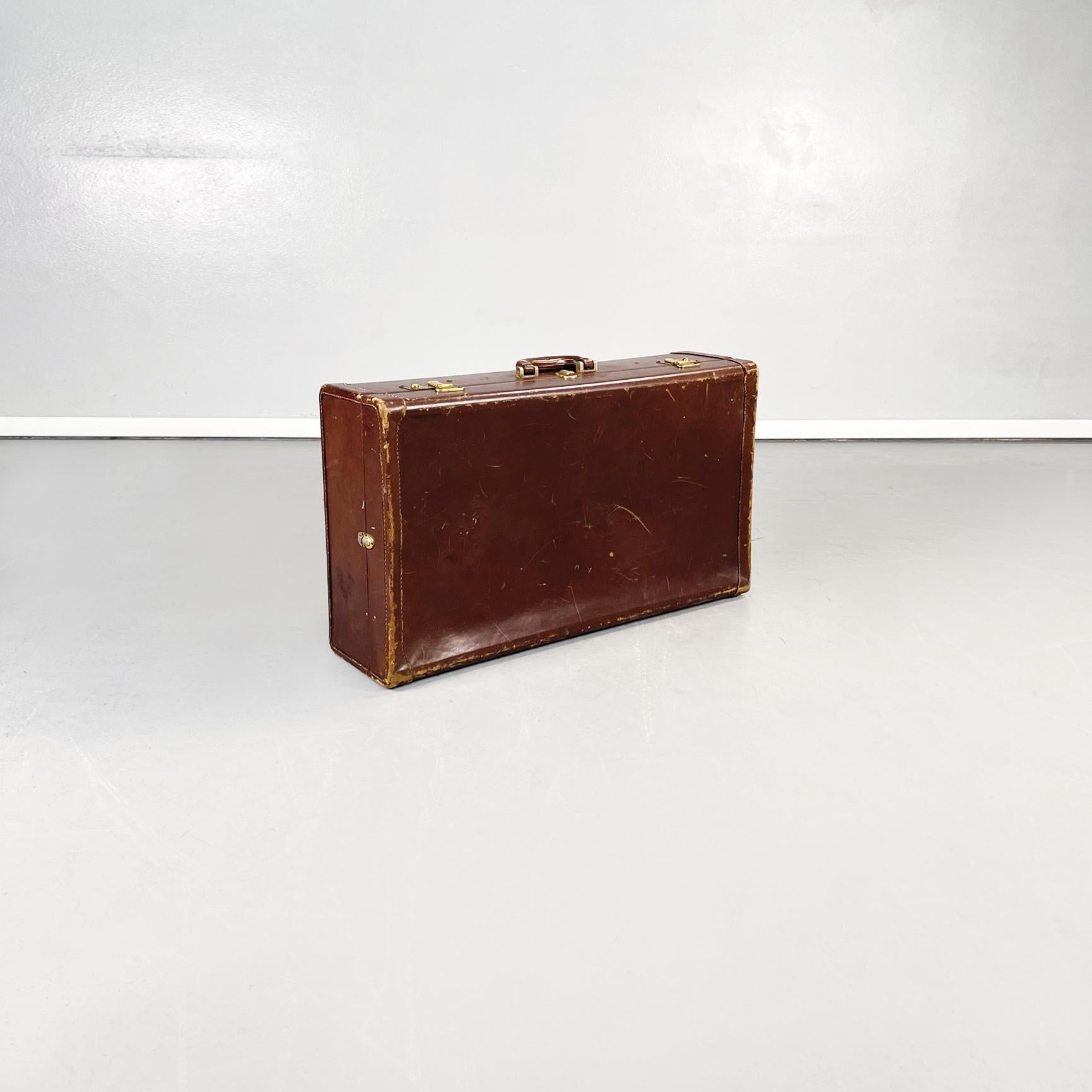 Bagage italien moderne du milieu du siècle en cuir brun et tissu beige, années 1970.
Valise rectangulaire en cuir brun. Fermeture en laiton, poignée présente. Intérieur en tissu beige avec deux poches élastiques et de fines lanières en cuir brun.