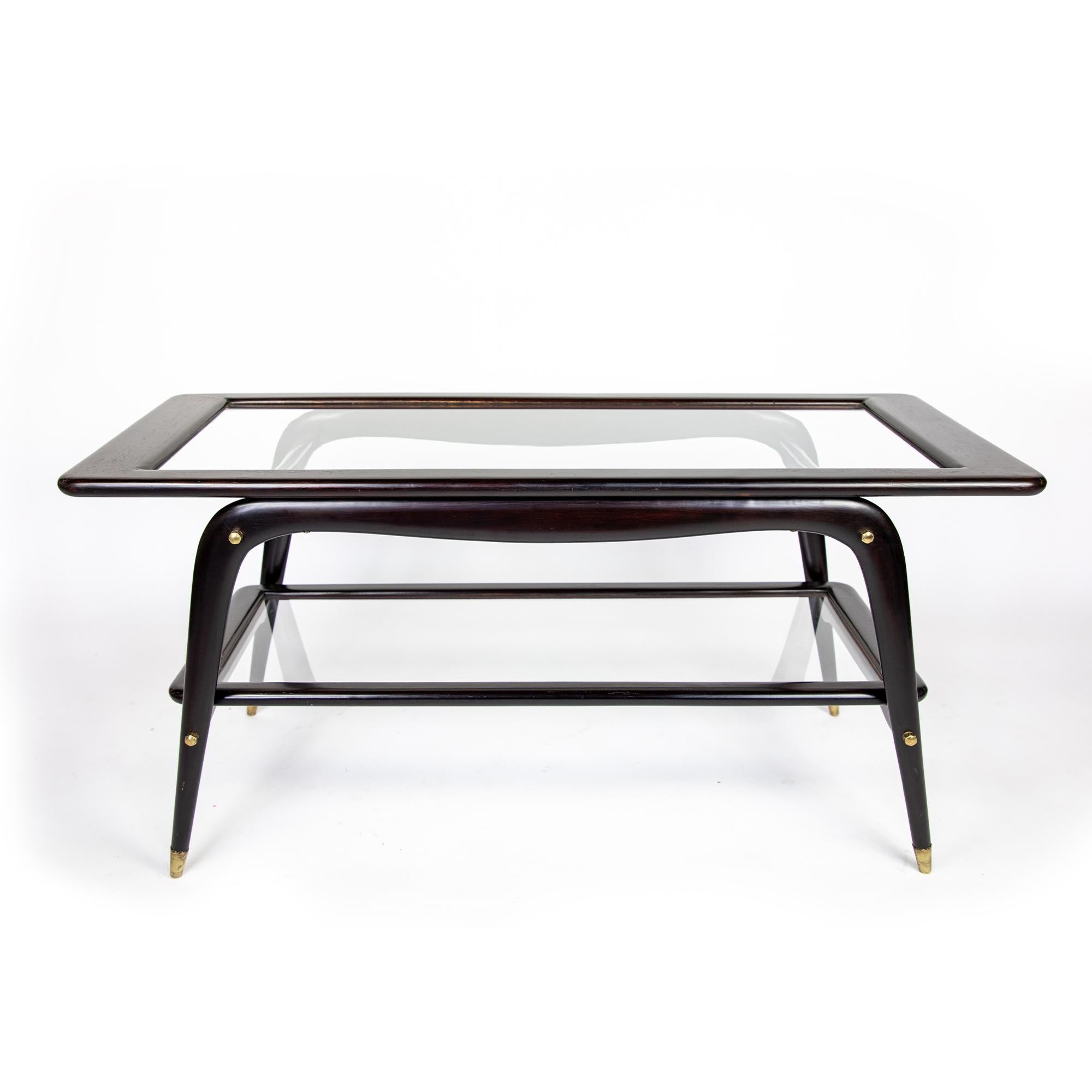 Coffee Table, Cesare Lacca Style, Mahogany Brown, Glass, Brass, Italy 1950s.

This dark brown Italian coffee table attributed to Cesare Lacca is made of solid mahogany wood, tempered glass and polished brass details. It has a carved sculptural