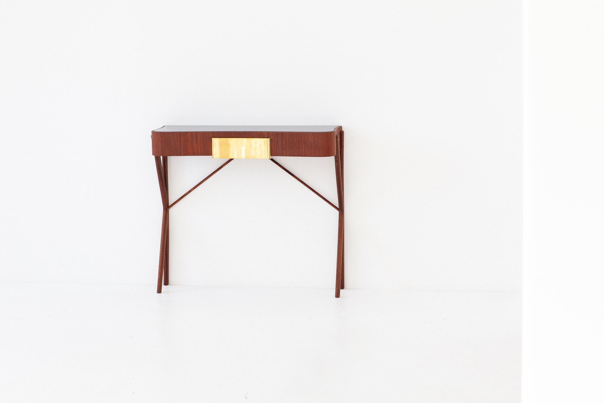 A modern console table, manufactured in Italy during the 1950s.

Made of mahogany wood , brass and black retro lacquered glass top.

Fully restored: As we normally prefer, the original finish has been completely removed to bring the wood back to