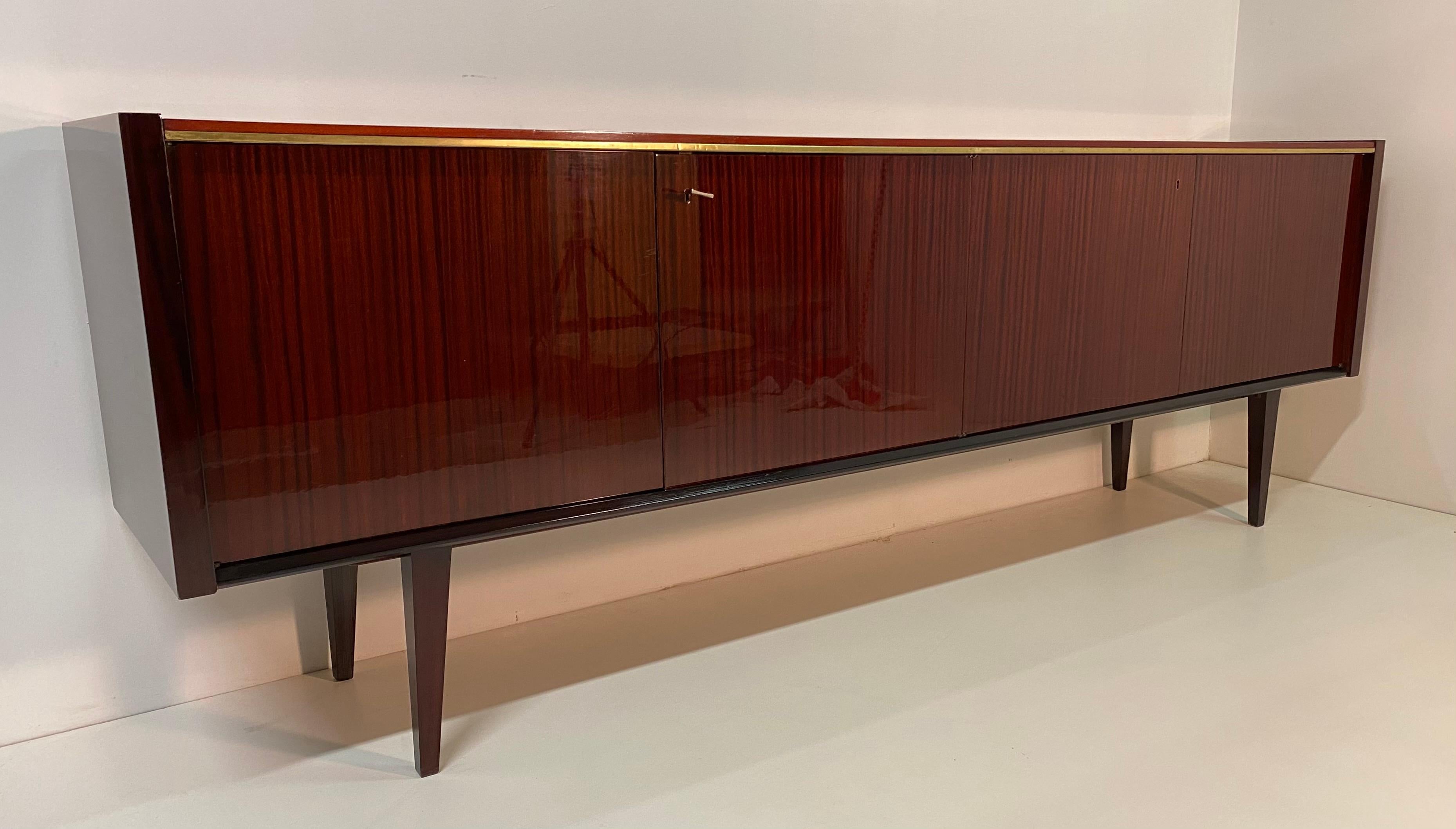 Italian sideboard of the 1960s veneered in mahogany with brass profile.
The sideboard is in excellent condition with some slight signs of aging.