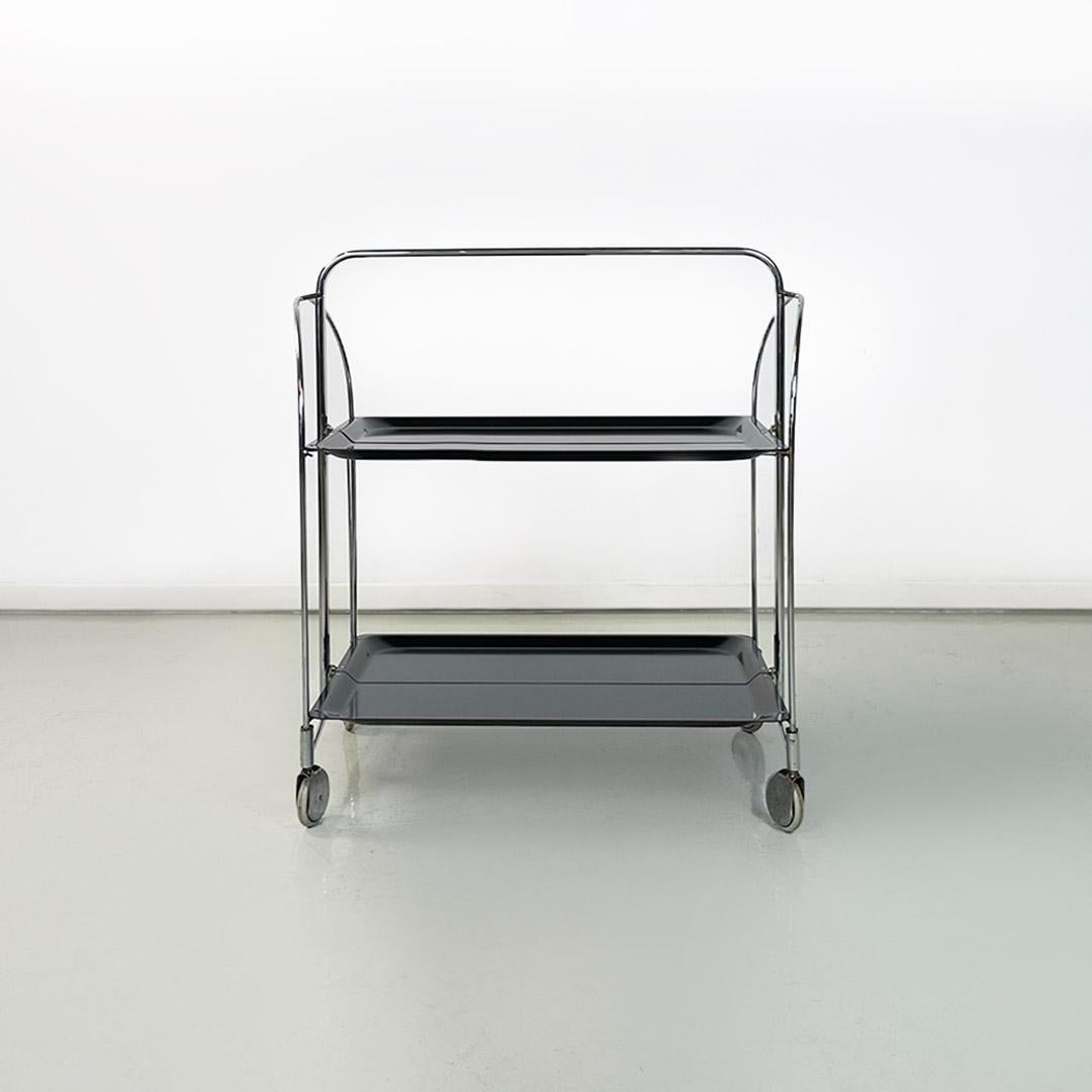 Italian mid century modern chromed metal and black plastic food trolley on wheels, 1960s
Food trolley with chromed metal rod structure, on wheels, usable by opening one or both halves that compose it and totally foldable on itself. Provided with two