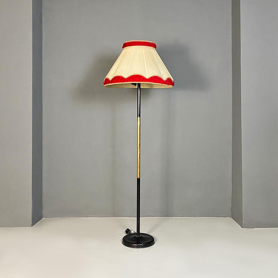 Italian Mid-Century Modern metal, brass and beige and red fabric floor lamp, 1940s.
Floor lamp with round base in black metal, stem in metal and brass and lampshade in truncated cone pleated fabric in shades of beige with upper and lower part of