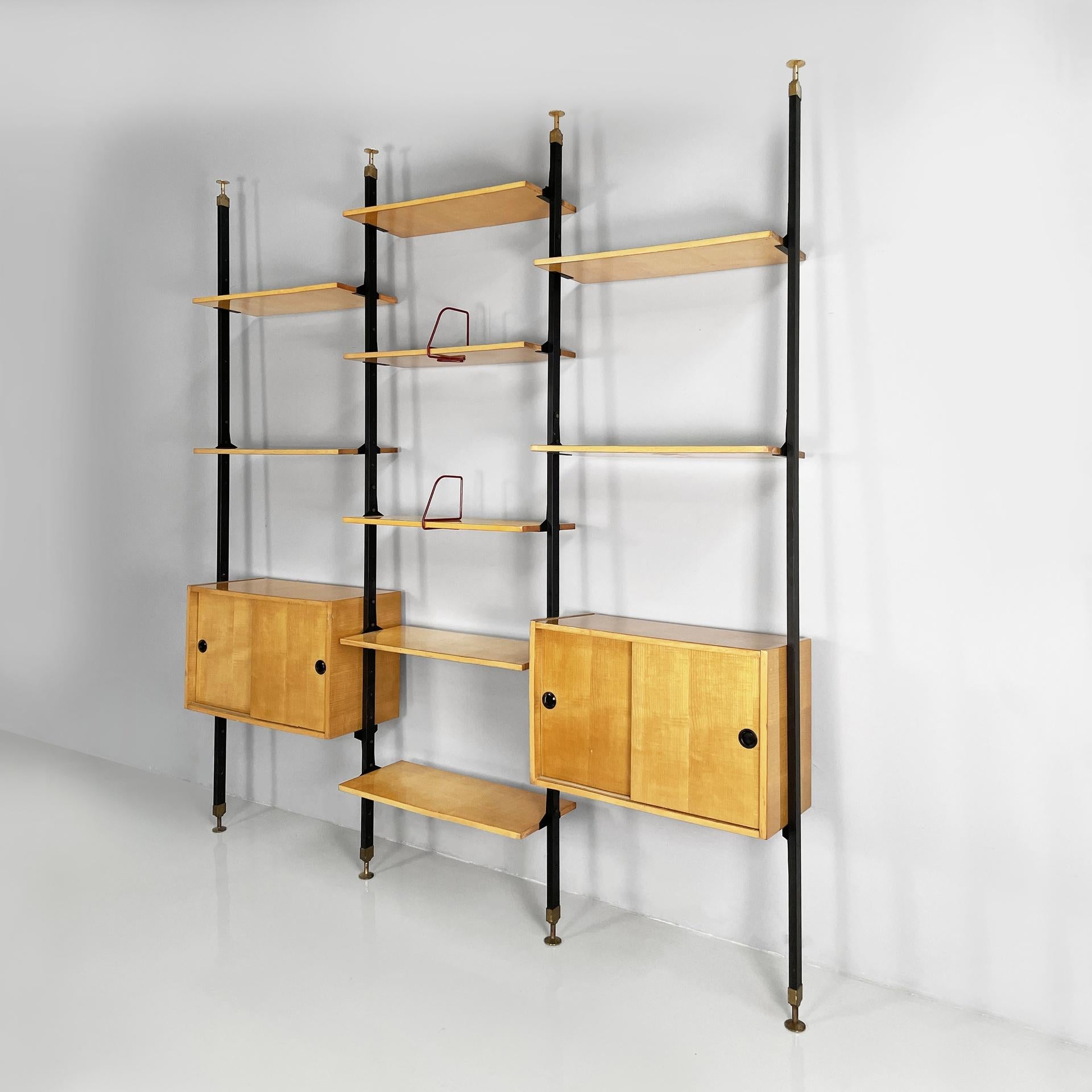 Italian mid-century modern modular bookcase in wood and black metal, 1960s
Modular floor-to-ceiling bookcase in light wood and black painted metal, composed of six rectangular shelves and two storage modules. The compartments have a sliding opening