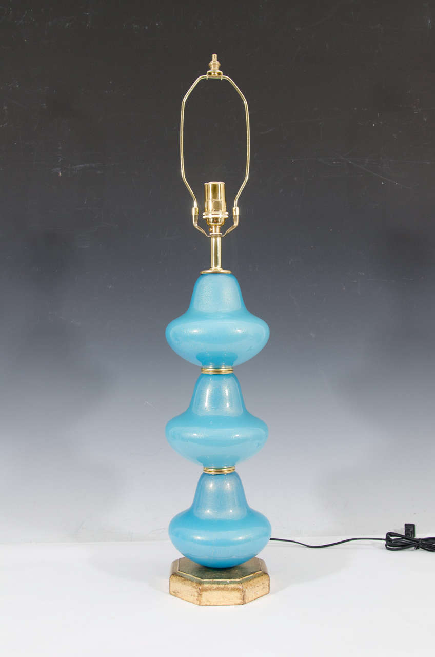 A vintage circa 1960s pair of turquoise and gold stacked bells shaped Murano glass table lamps with gold flecks and gold leaf wooden bases. Newly rewired and in excellent vintage condition. Old paper makers labels on the lamps.