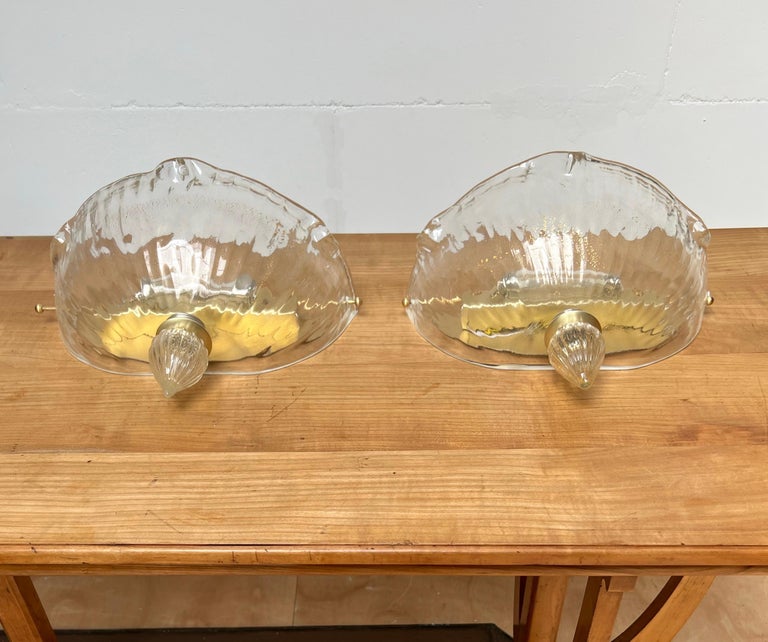 Great looking, easy to mount and beautifully mouth blown pair of glass wall lights.

This marked and labelled pair of Italian glass art sconces are acquired as a complete set of five light fixtures. The other three are flush mounts and they will