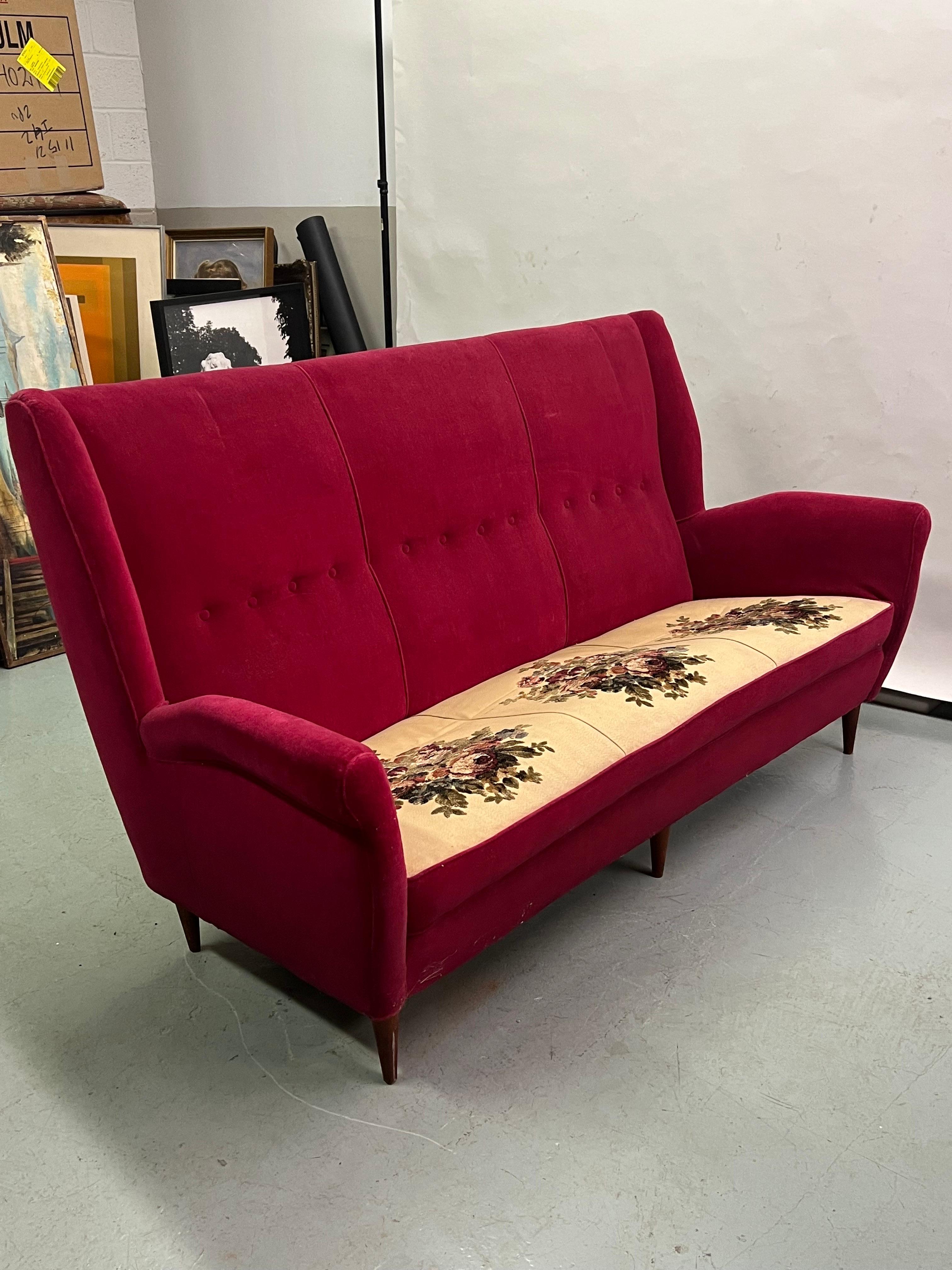 An elegant, stunning Italian Mid-Century Modern Sofa with modern neoclassical influences by Gio Ponti for Editions ISA, Bergamo, circa 1955. This sofa features a high back, wingback ears, a distinctive sculpted profile, refined sensuous lines and