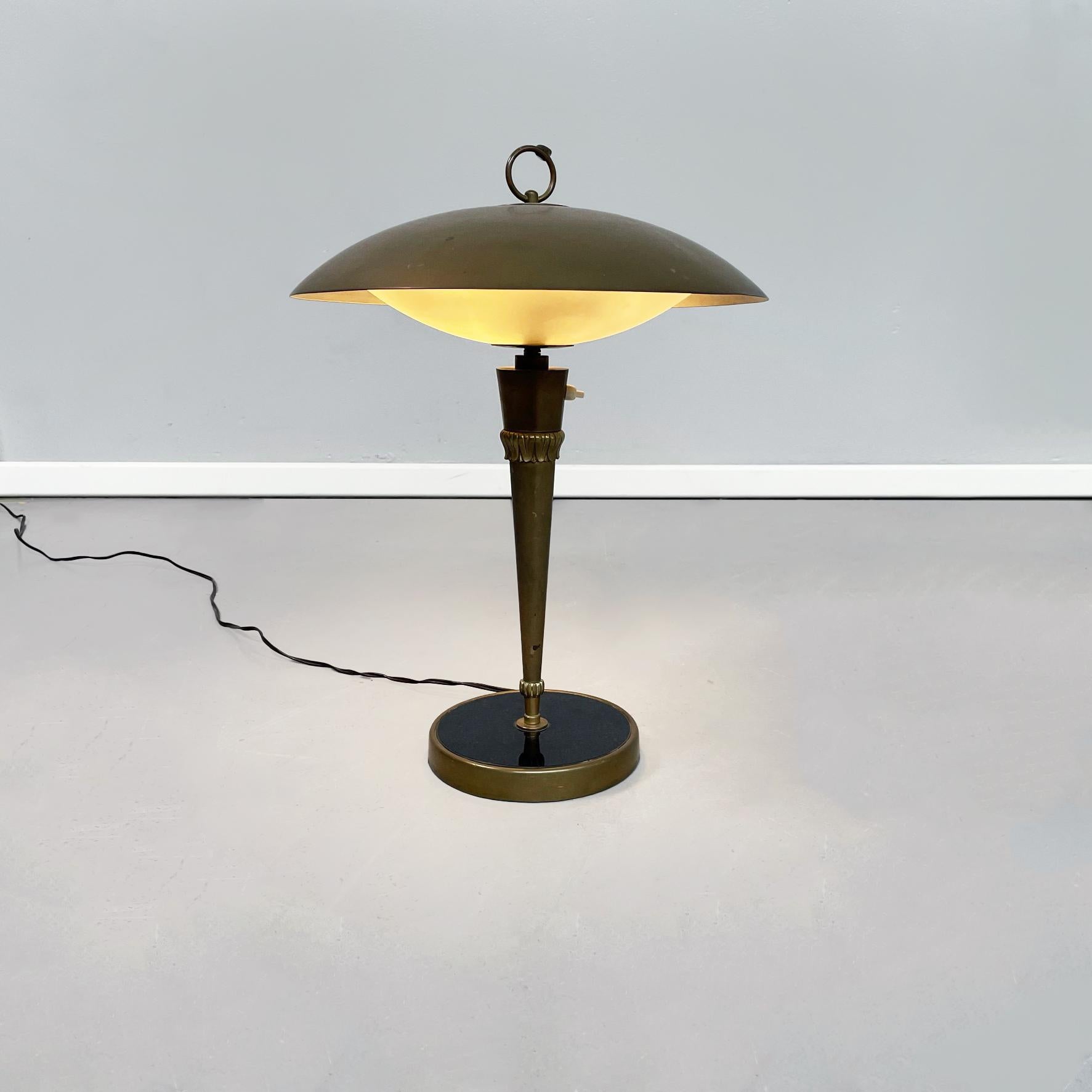 Italian Mid-Century Modern opaline glass and brass table lamp, 1960s.
Table lamp with round base in brass and black glass original from 1950/60 period. The central structure is composed of a single finely decorated conical rod, on which there is the