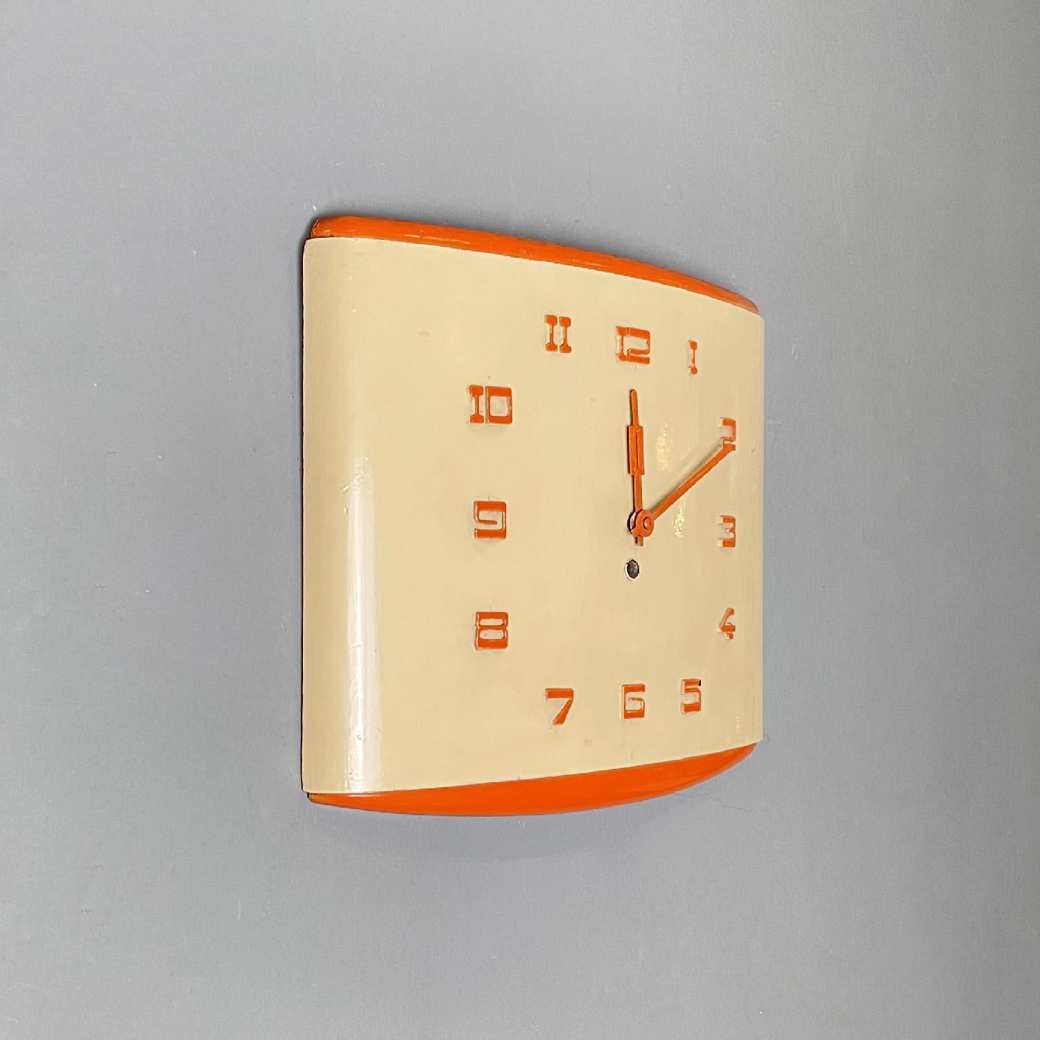 Italian mid-century modern orange and beige rectangular wall clock, 1960s
Rectangular wall clock in cream yellow and orange lacquered wood. The structure is slightly domed and rounded toward the outside. It has slightly thick numbers that are made
