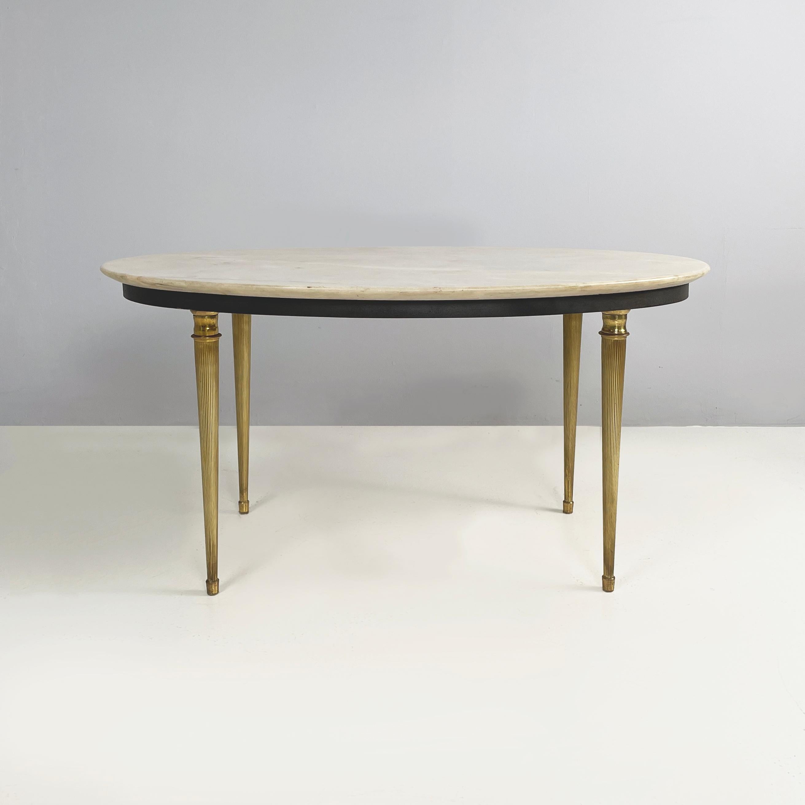 Italian mid-century modern Oval coffee table in marble and brass, 1950s
Coffee table with oval top in light marble. The structure on which it rests is in black painted metal. The round section brass legs are finely crafted: the shape resembles a