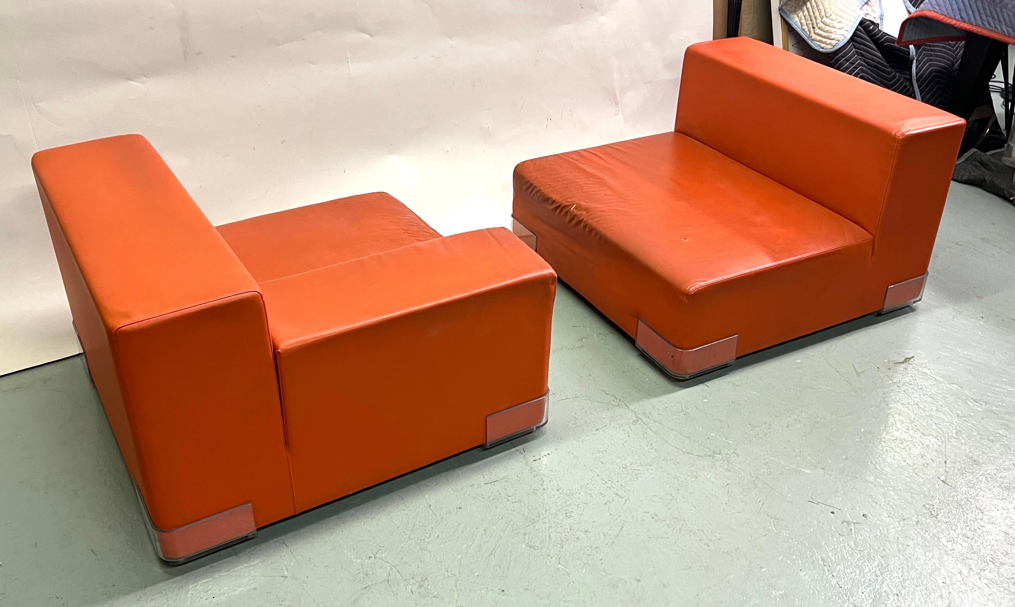 An Iconic Italian Mid-Century Pair of Lounge Chairs by Piero Lissoni in a sleek, contemporary, low, square form circa 1970-1975. The pieces are modular, multi-functional and will form a sofa / settee. It is decorated in a bright orange rubberized