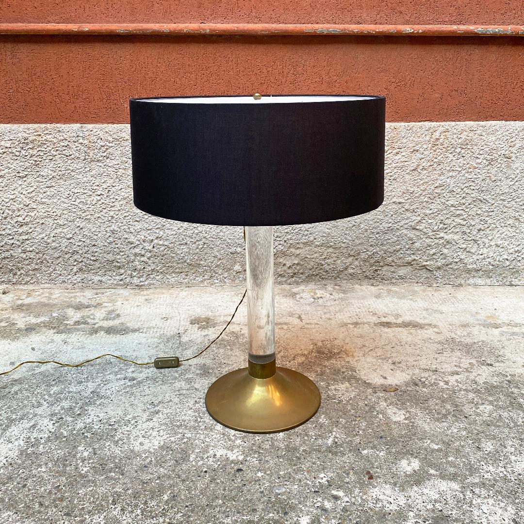 Italian Mid-Century Modern plexiglass and brass table lamp, 1960s
Table lamp with brass base and central stem in plexiglass, cylindrical lampshade in black fabric and two Directional ceramic lamp holders with brass joint.

Very good condition,