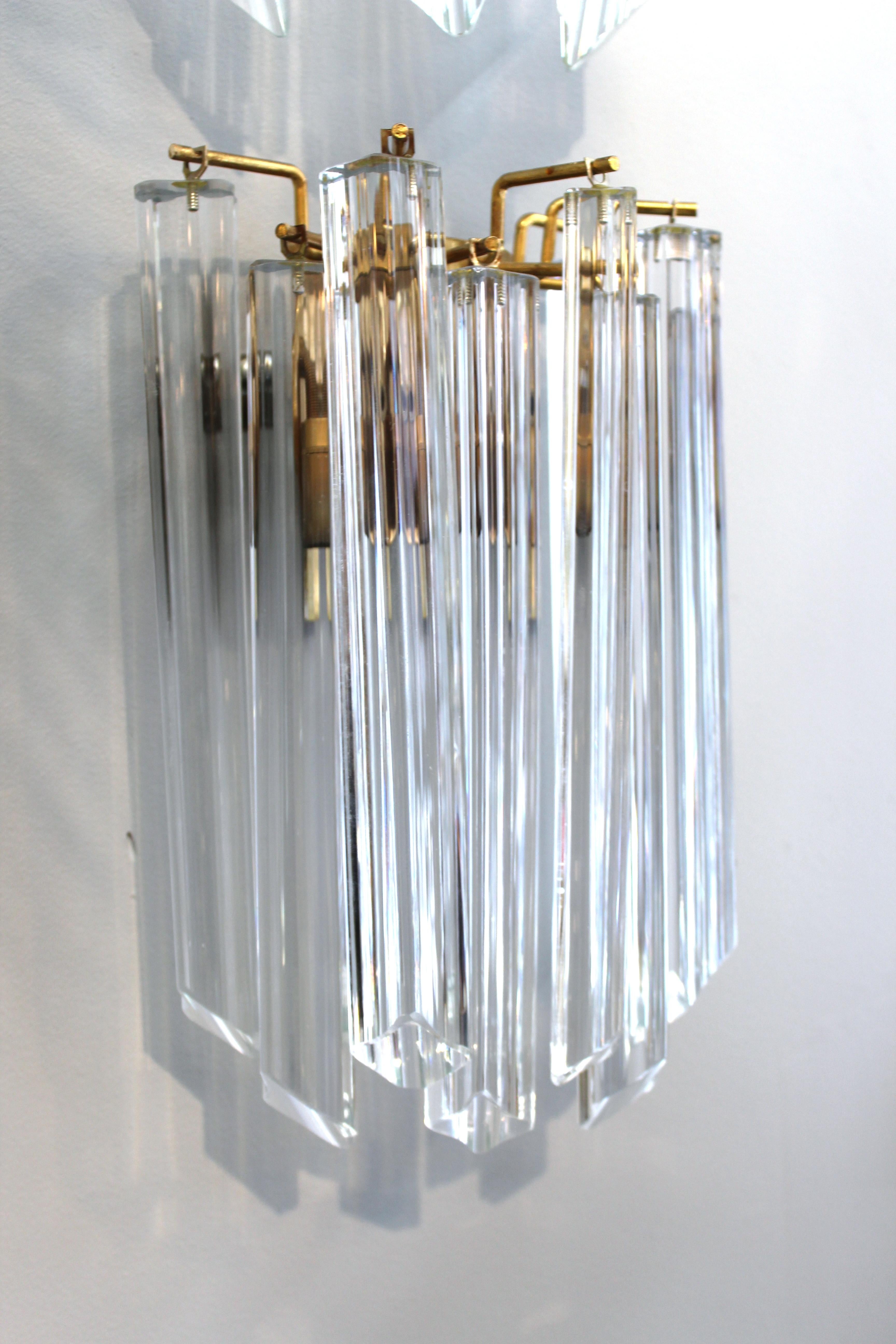 Pair of Italian Mid-Century Modern wall sconces with quadriedri prisms attached to a metal structure attributed to Venini. Each sconce can hold two light bulbs. A few minor chips to a couple of prisms and age-related tarnish to the metal.