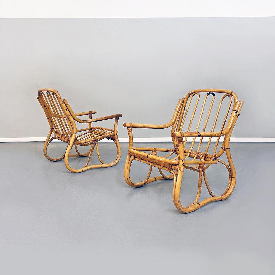 Italian Mid-Century Modern rattan armchairs with armrests, 1960s 
Rattan armchairs with armrests composed of curved and intertwined canes.

Good general conditions.

Measurements 64 x 75 x 83 H cm.