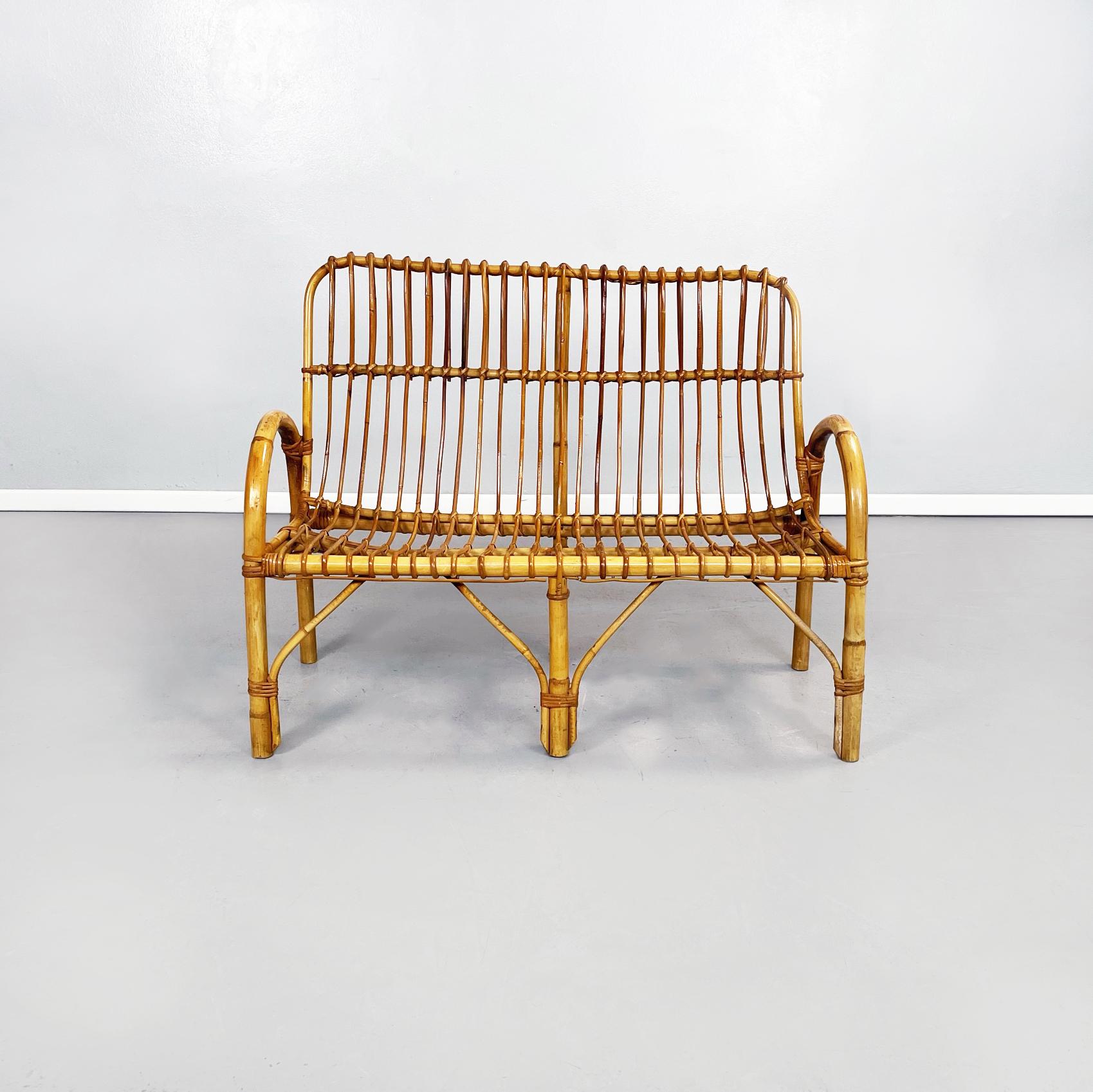 Italian Mid-Century Modern Rattan bench with armrests, 1960s
Bench made of curved rattan canes, with intertwining. The seat and back are slightly curved. The semi-oval armrests are composed of thick rods.
1960s.
Excellent conditions, in original