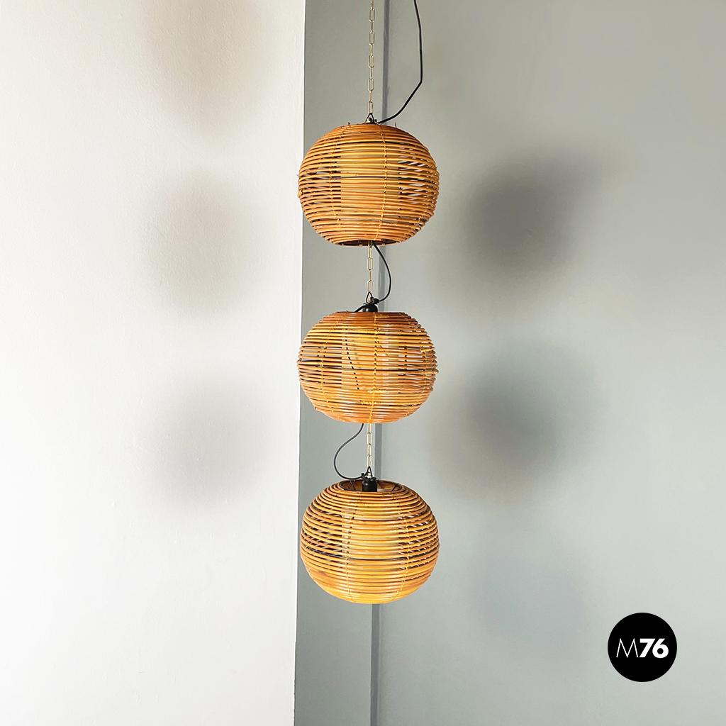 Italian Mid-Century Modern Rattan chandelier with 3 spherical lampshade, 1960s
Rattan chandelier composed of 3 light sources, which each light has its own spherical rattan lampshade, reminiscent of oriental lanterns. The 3 lampshades are joined by